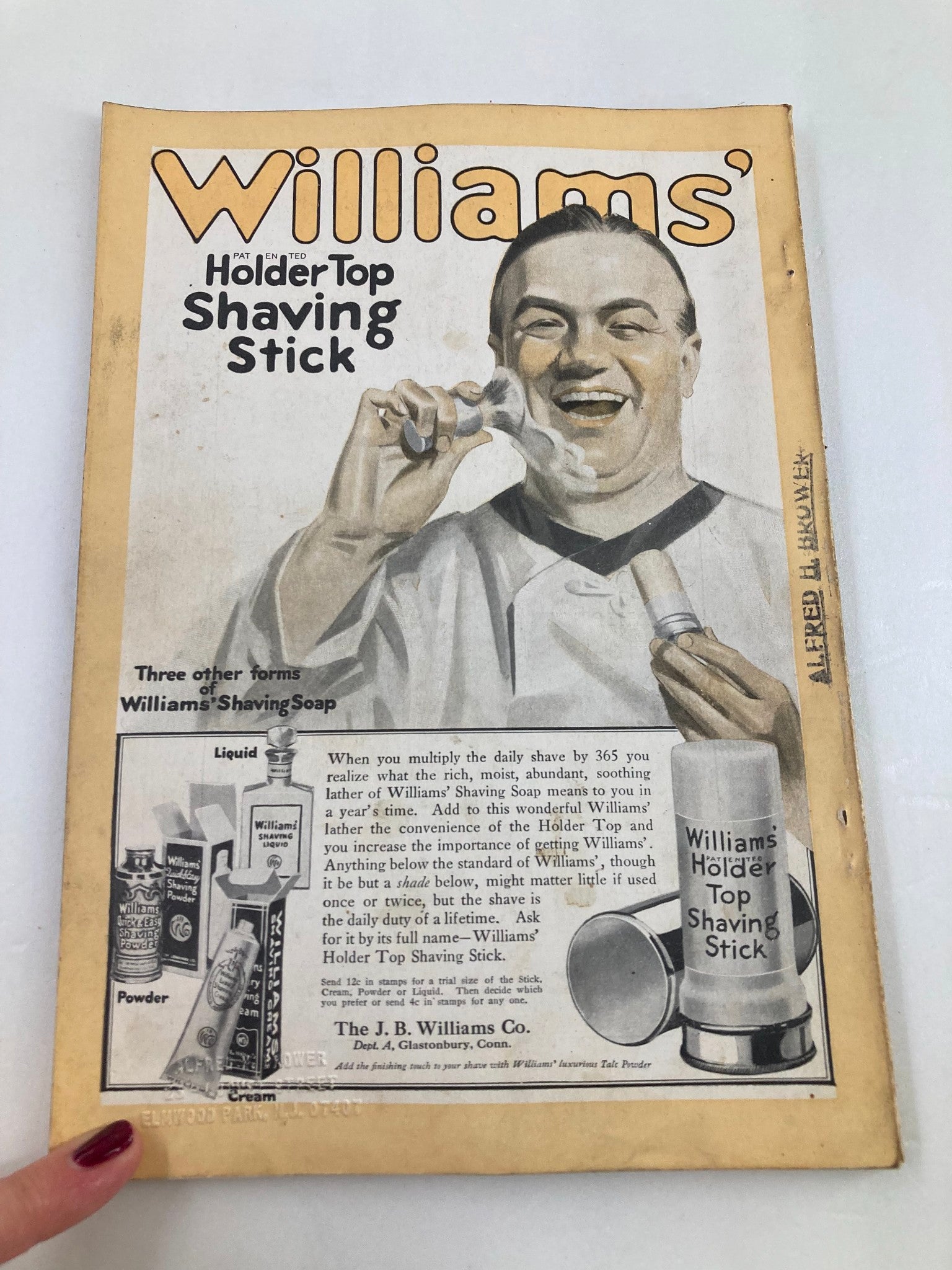 Vintage advertisement featuring a smiling man demonstrating Williams' Holder Top Shaving Stick, showcased on the front page of The National Geographic Magazine August 1917.