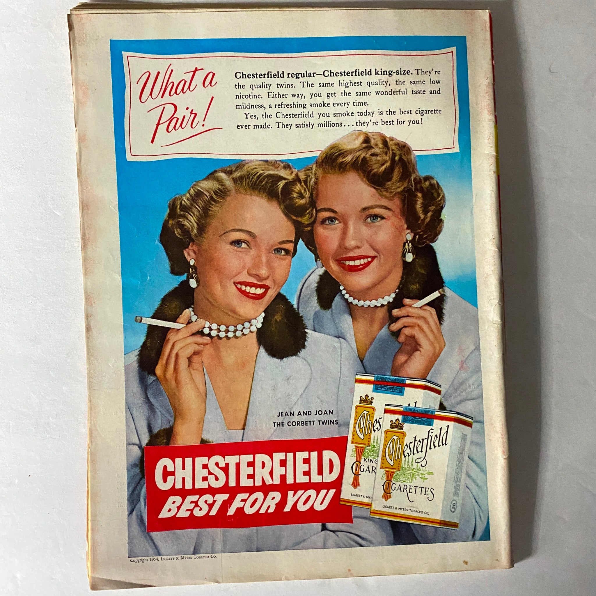 Vintage Chesterfield cigarette advertisement featuring the Corbett twins, promoting Chesterfield cigarettes with a catchy slogan, reflecting mid-20th century marketing aesthetics.