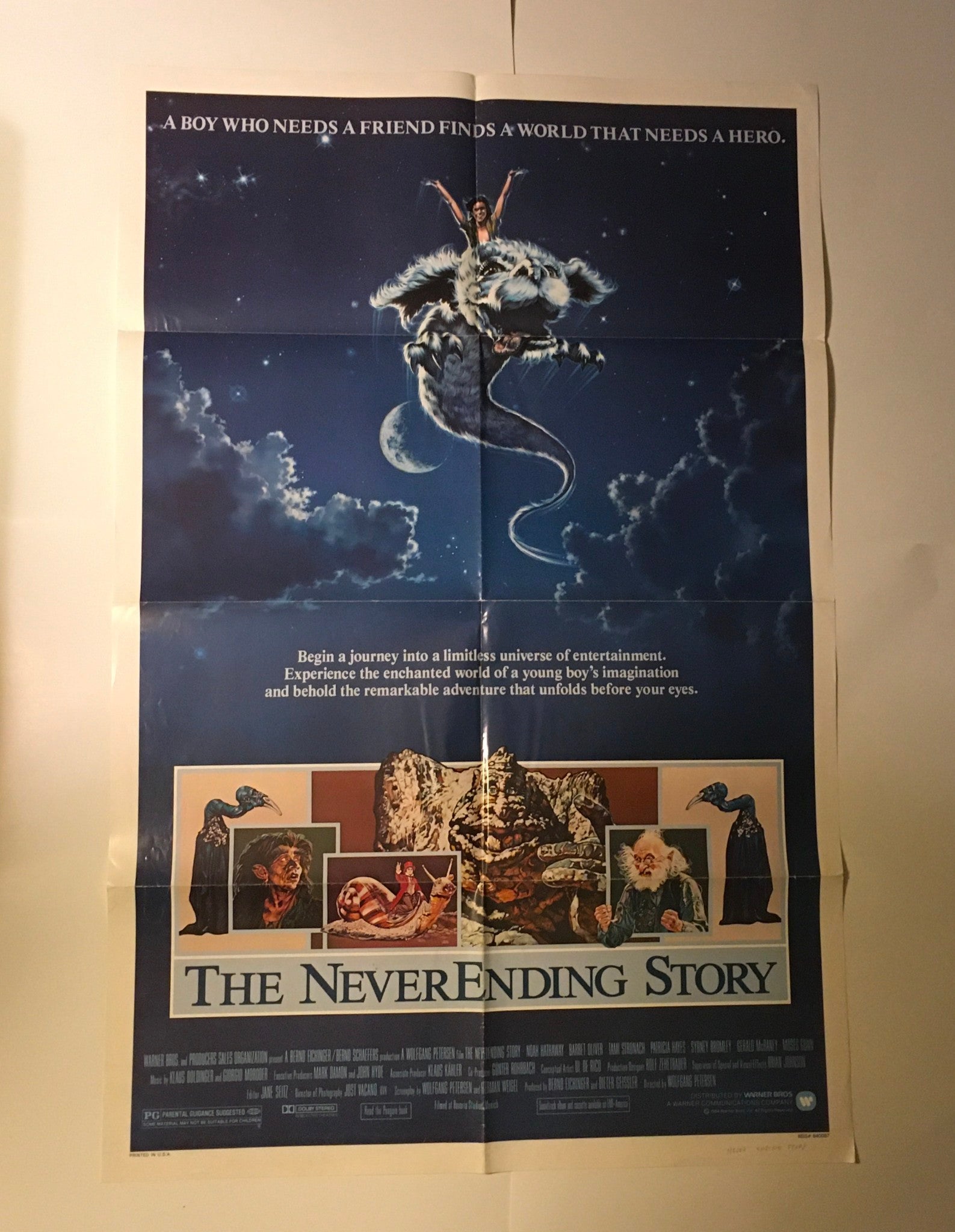 1984 The Never Ending Story 41" x 27" original movie poster showing a boy with a dragon-like creature against a celestial backdrop, highlighting themes of friendship and adventure.