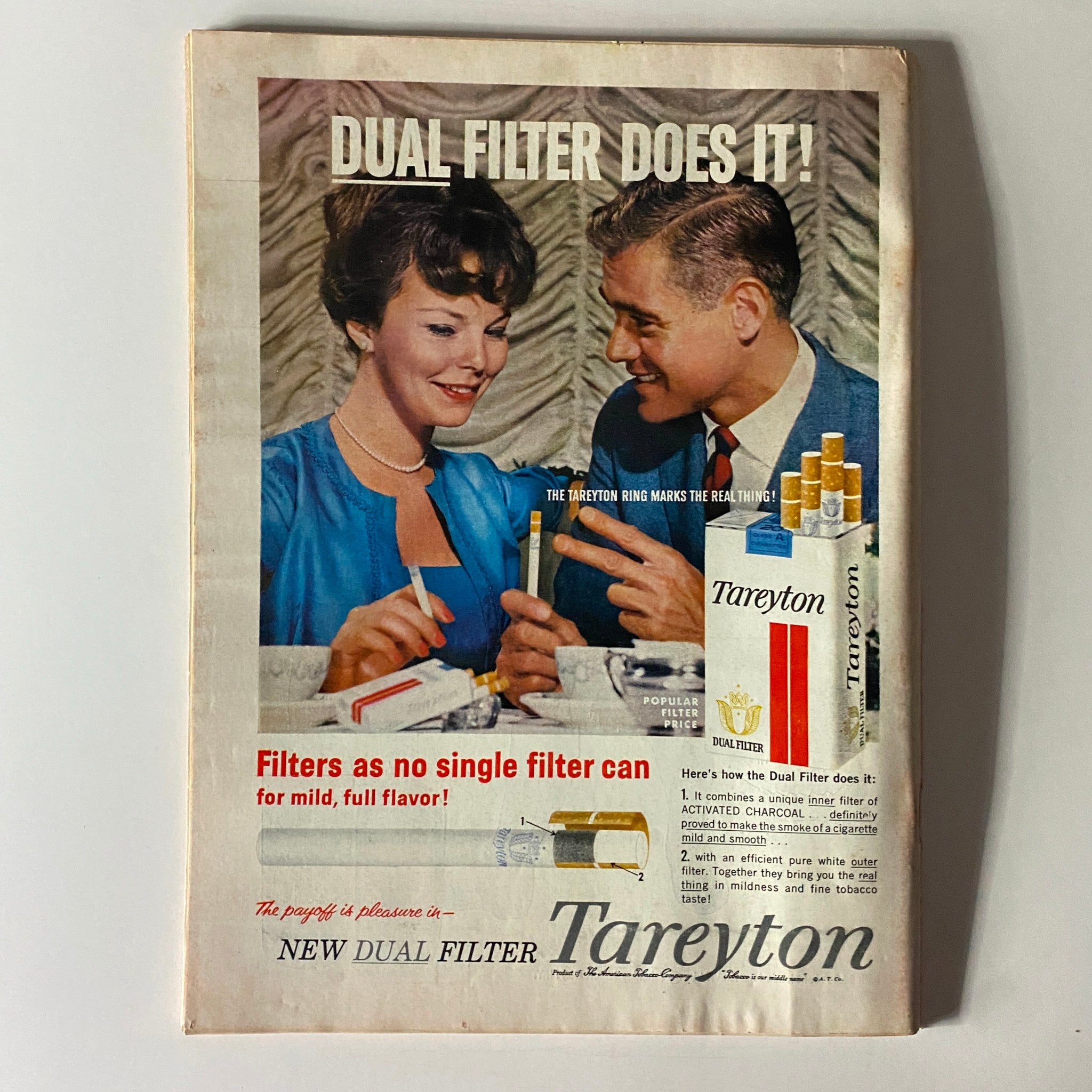 Advertisement for Tareyton cigarettes featured in a vintage magazine, emphasizing dual filter technology with a couple enjoying a moment together.