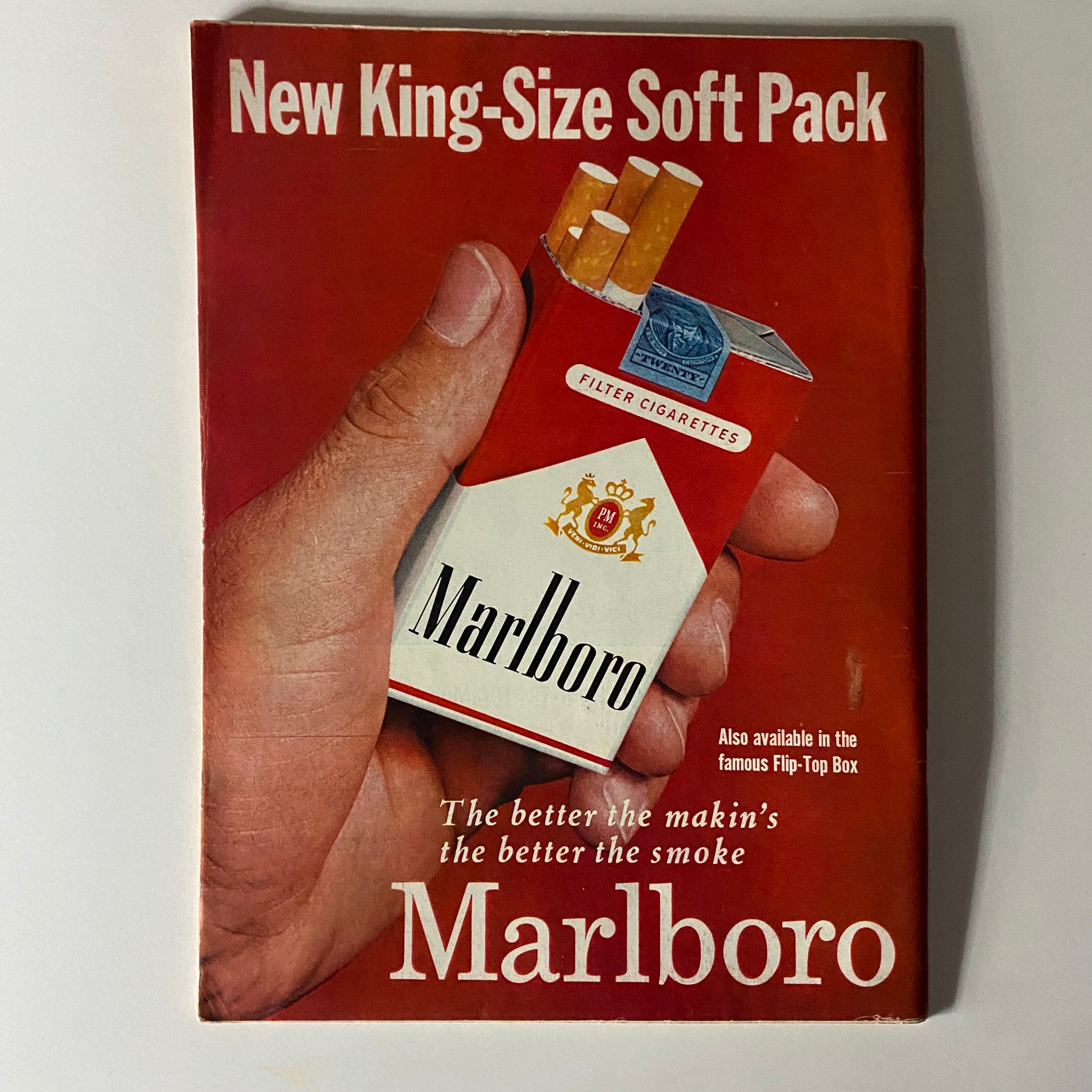 Vintage Marlboro advertisement featuring a hand holding a new king-size soft pack cigarette box, highlighting classic branding.
