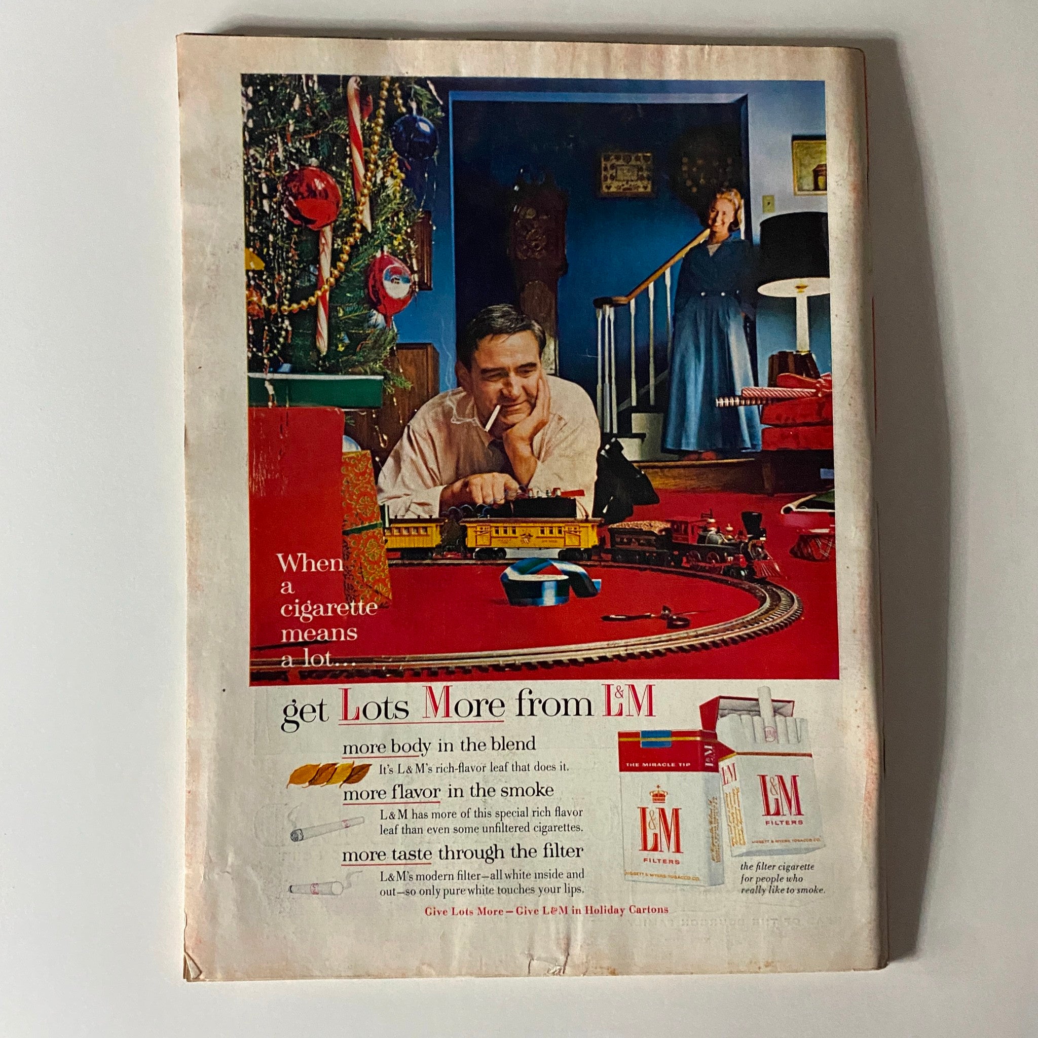 Back cover of a vintage advertisement magazine from Time Magazine, highlighting L&M cigarettes with a family scene during the holidays.