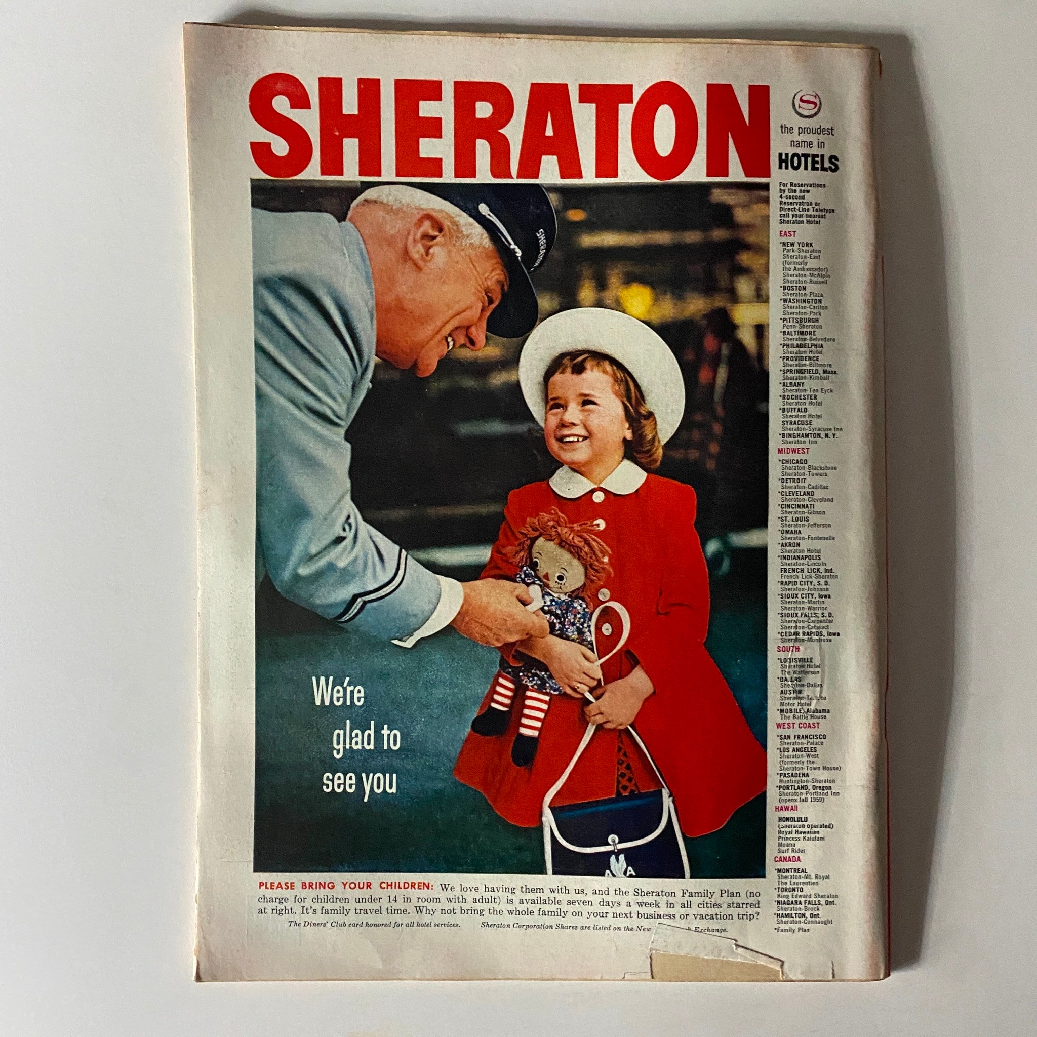 Vintage Sheraton Hotels advertisement featuring a smiling girl with a doll and a hotel staff member, illustrating family-friendly hospitality and charm.