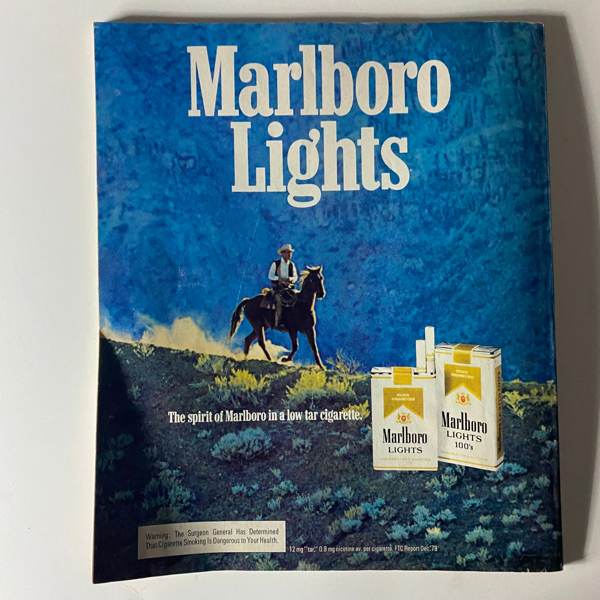 Vintage Marlboro Lights advertisement from Harper's Bazaar Magazine August 1980, featuring a cowboy on horseback with cigarette products.