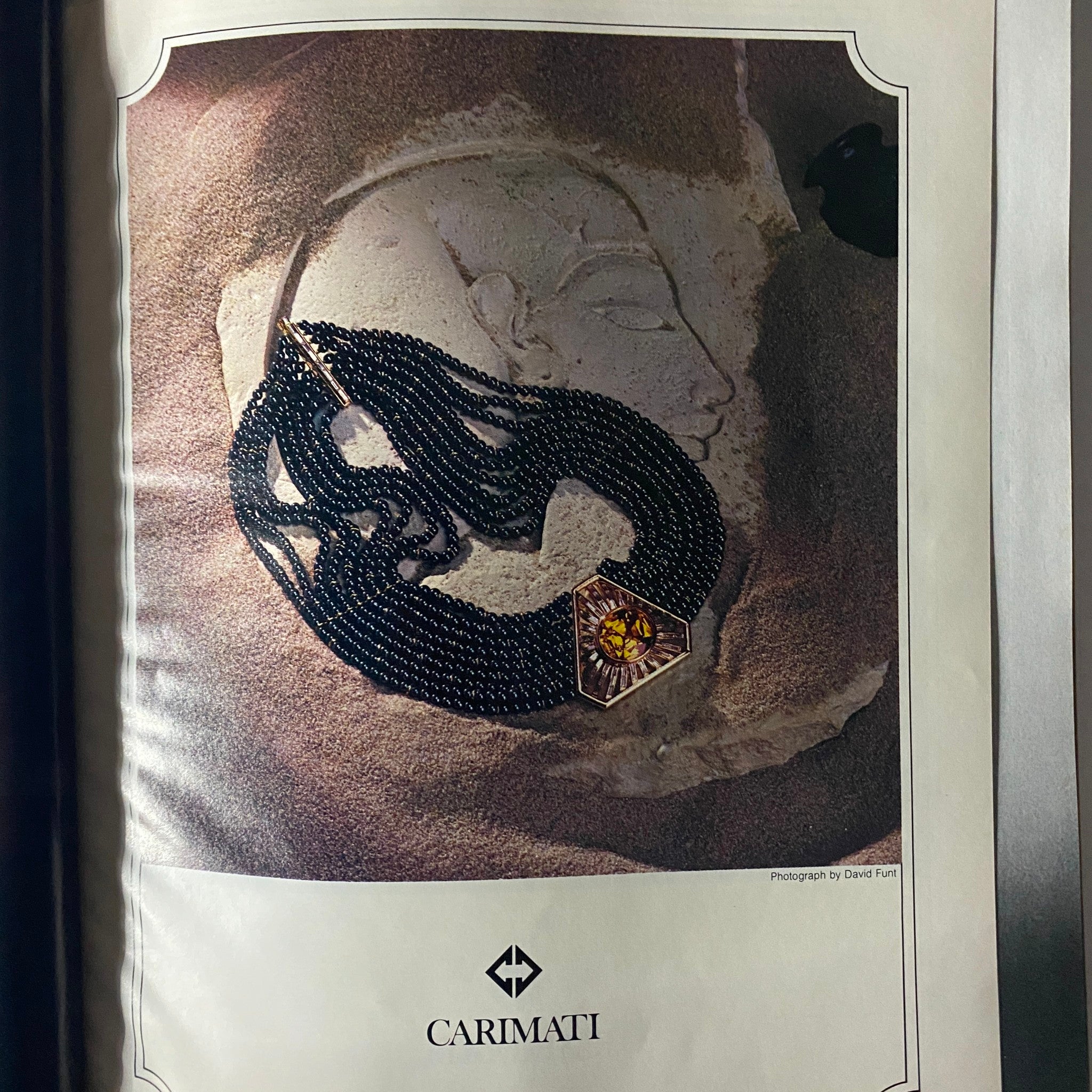Jewelry advertisement featuring a stunning necklace by Carimati, showcased against an artistic background, from the December 1979 issue of Town & Country Magazine.