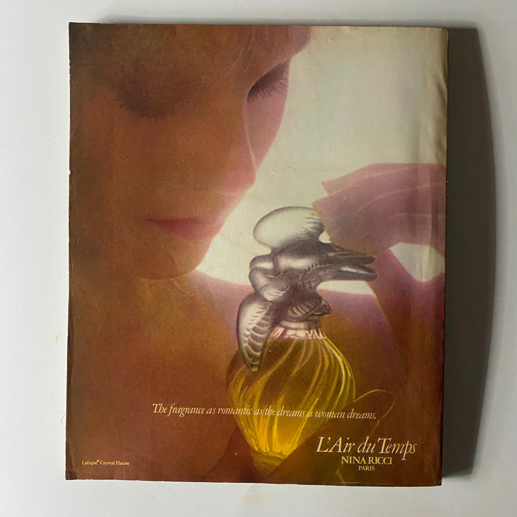 Perfume advertisement for L'Air du Temps by Nina Ricci, displaying a woman holding an elegant crystal bottle, from the December 1979 issue of Town & Country Magazine.