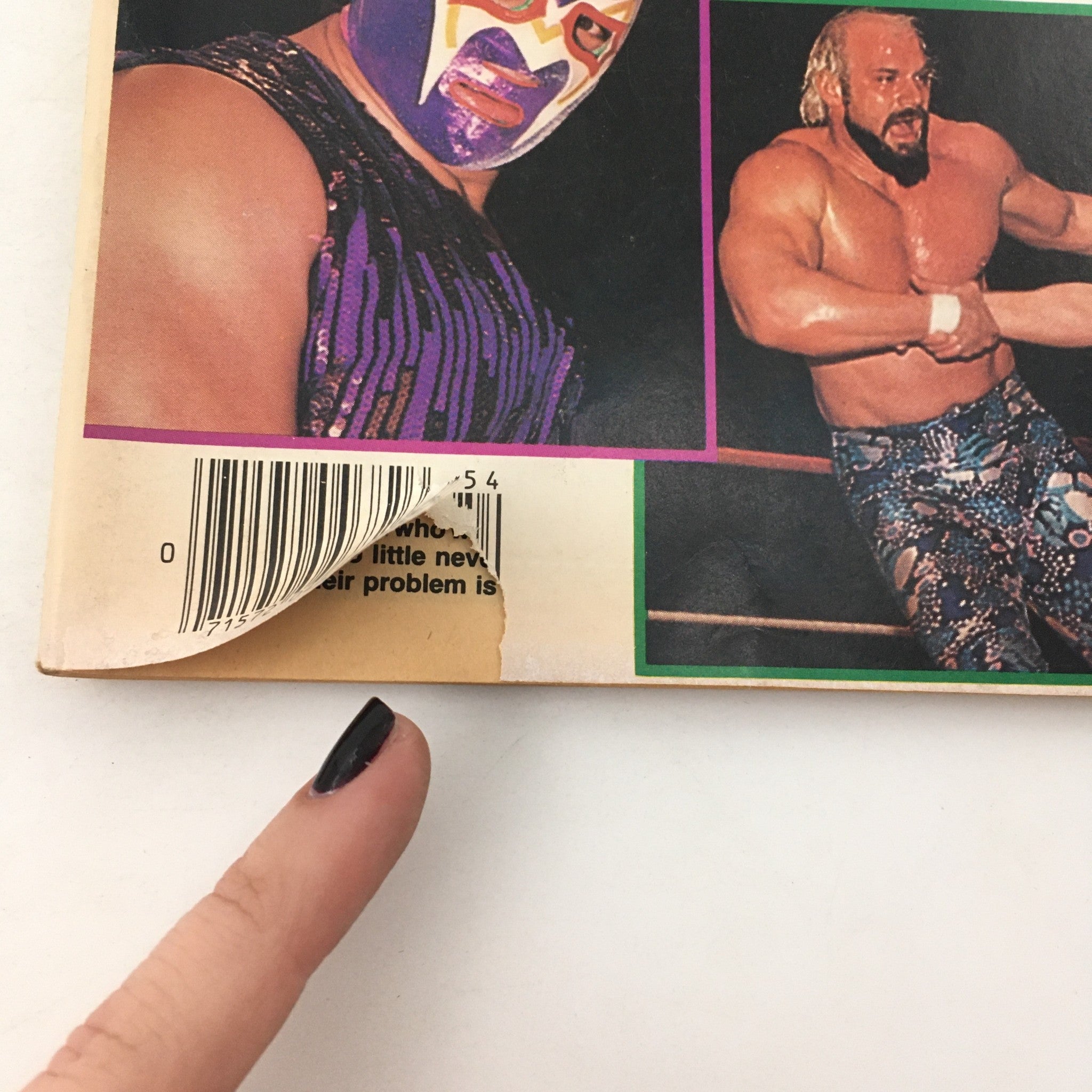 Back cover detail of Pro Wrestling Illustrated Magazine Spring 1985 featuring wrestlers with visible wear, a torn barcode corner, and a finger pointing at the magazine.