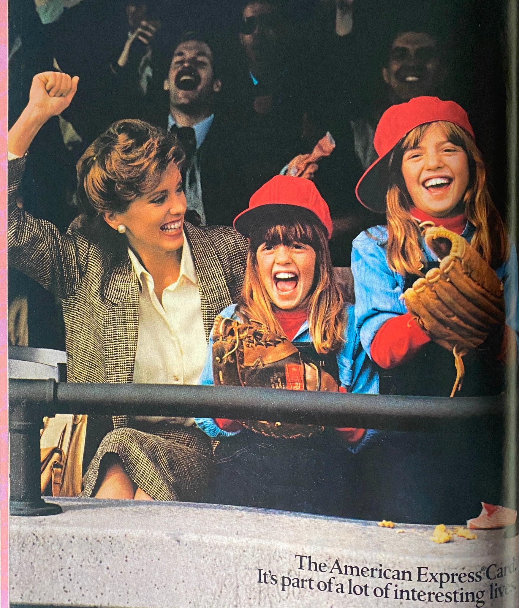 Image from Savvy Magazine October 1985 showing an enthusiastic woman and two girls at a sporting event, all wearing baseball caps and smiling joyfully. Highlights themes of family bonding and leisure in the context of the magazine's articles.