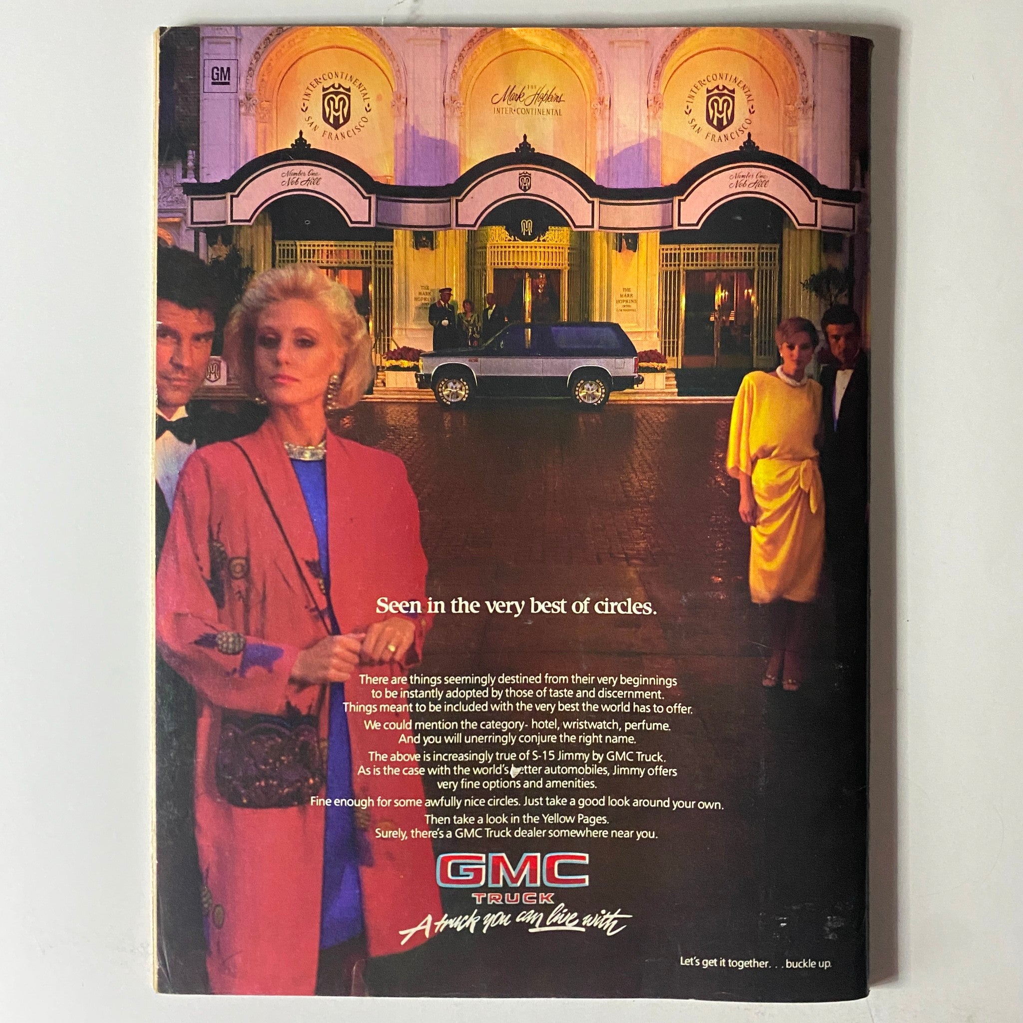 Back cover of Savvy Magazine October 1985 featuring an advertisement for GMC Truck. Evokes a luxurious lifestyle with stylish individuals in front of an upscale hotel, reflecting cultural trends of the 1980s.