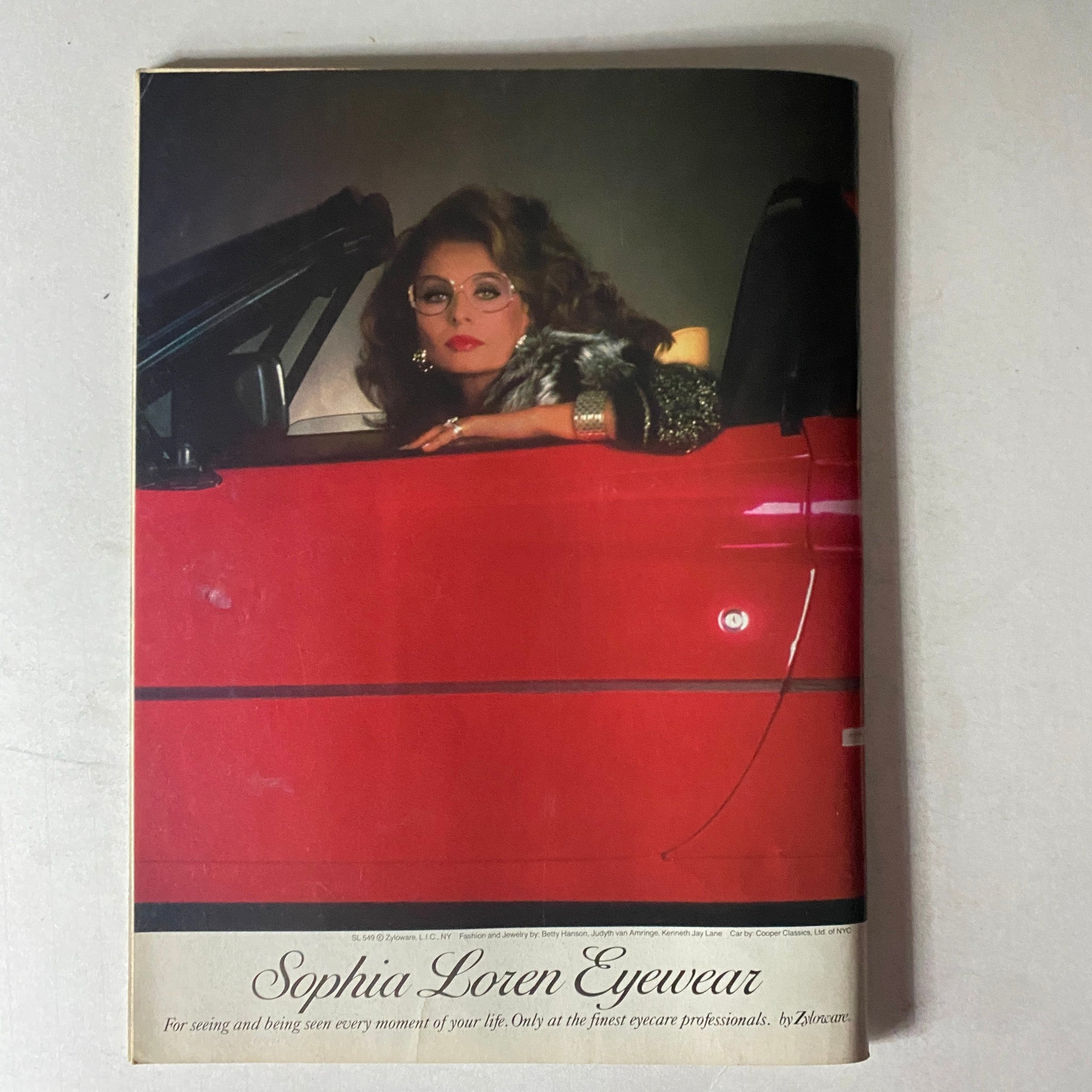 Savvy Magazine April 1986 advertisement for Sophia Loren Eyewear, featuring a stylish woman in a convertible, promoting elegance and professionalism.