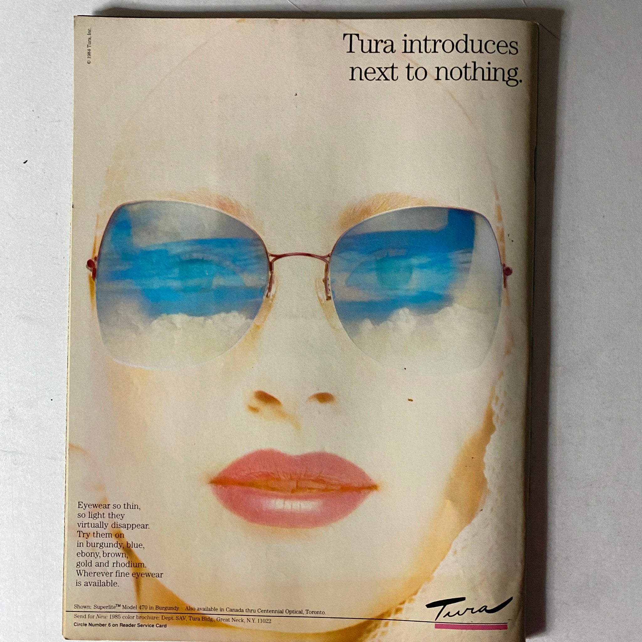 Tura eyewear advertisement from the Savvy Magazine December 1985 showcasing stylish sunglasses, promoting lightweight and fashionable eyewear options for modern women.