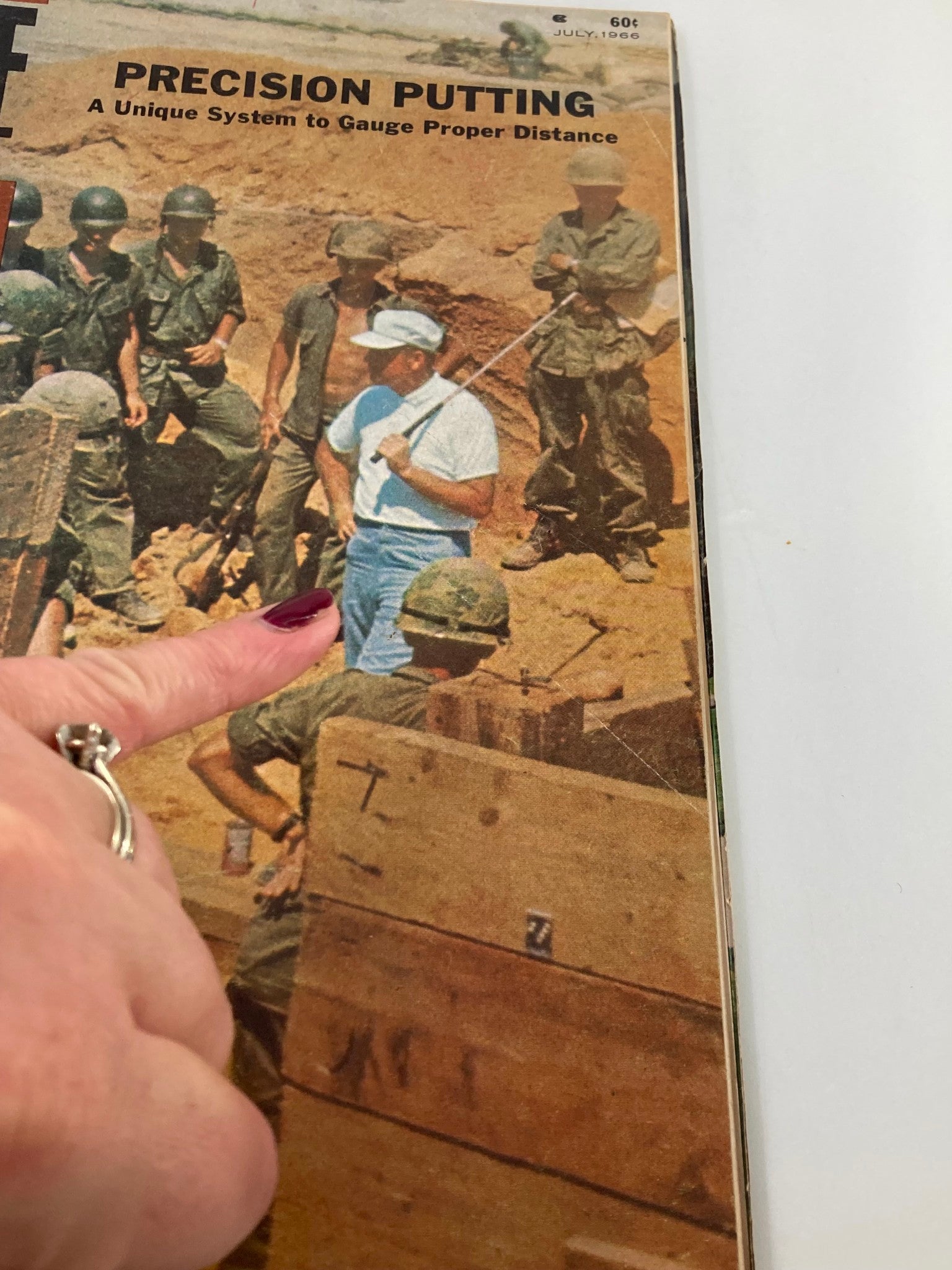 Close-up of the cover of VTG Golf Digest Magazine July 1966, highlighting the article 'Precision Putting: A Unique System to Gauge Proper Distance' with a focus on a golf instruction scene involving soldiers.