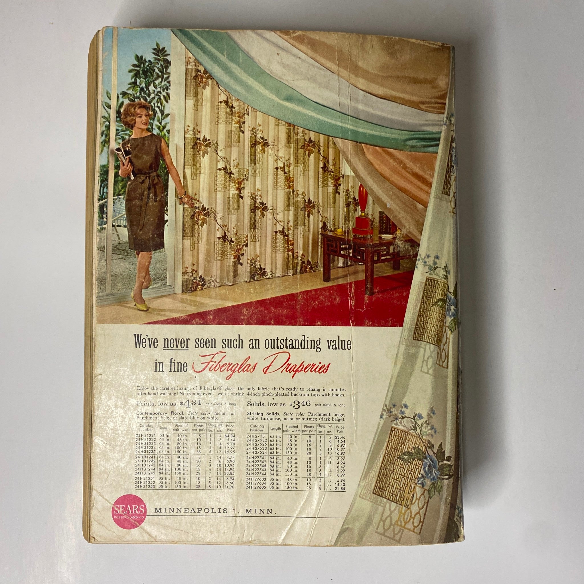 Cover of the 1960 Sears Fall and Winter Catalog featuring a woman in a stylish dress standing near fiberglass draperies and elegant furnishings.