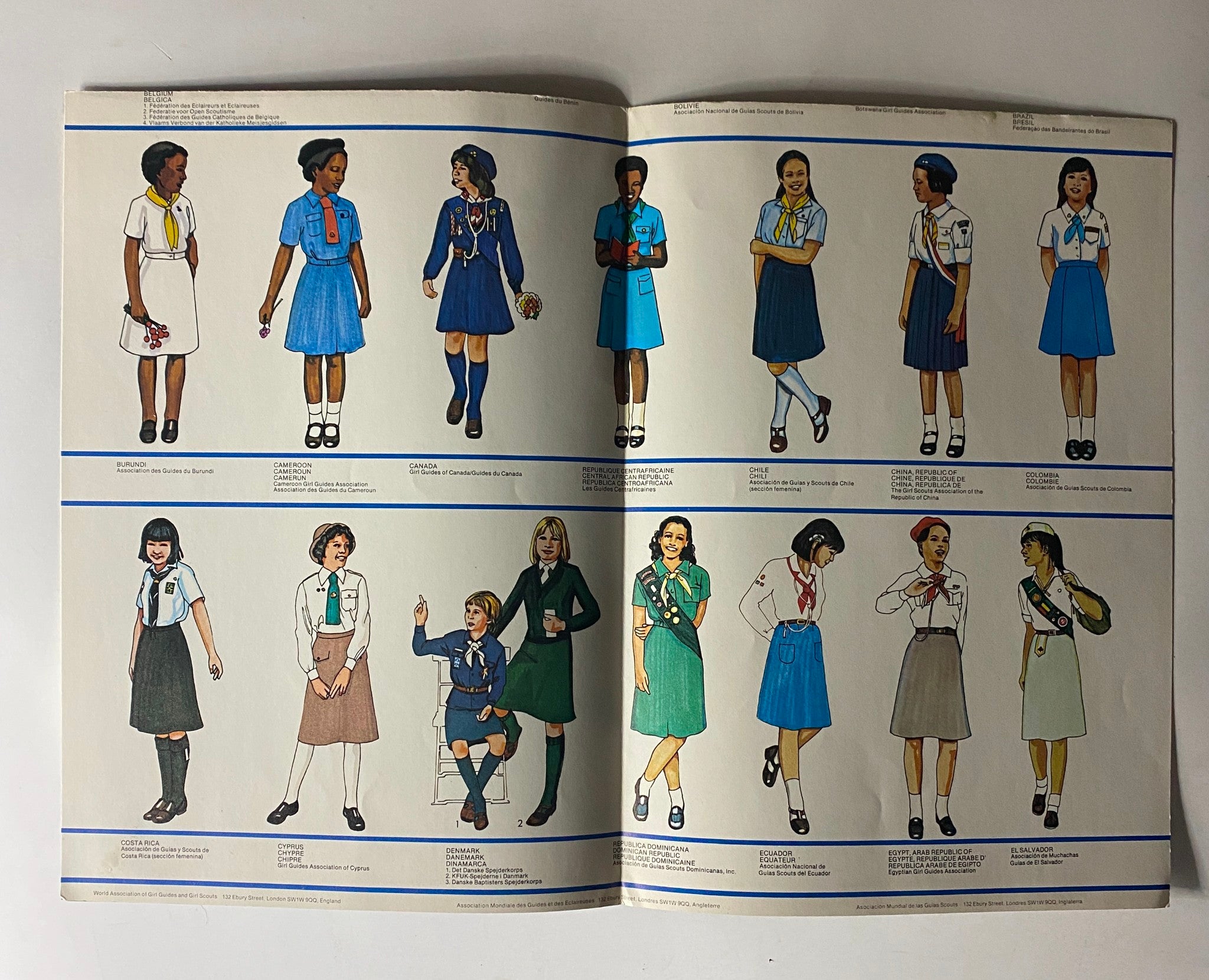 Page from the 1980 Uniform of the Girl Scout and Brownie Scout Equipment Catalog #1 displaying illustrations of Girl Scout uniforms from multiple nations, highlighting diverse styles and designs.