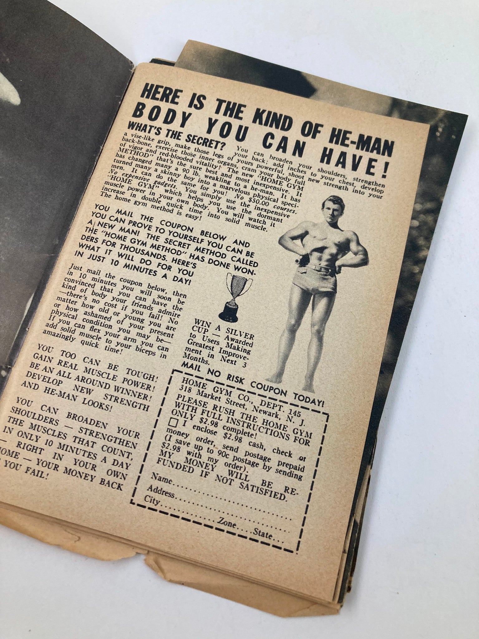 Interior page of the Vintage Carnival Pocket Magazine showcasing an advertisement for a home gym program with fitness advice and a vintage photograph of a muscular man.