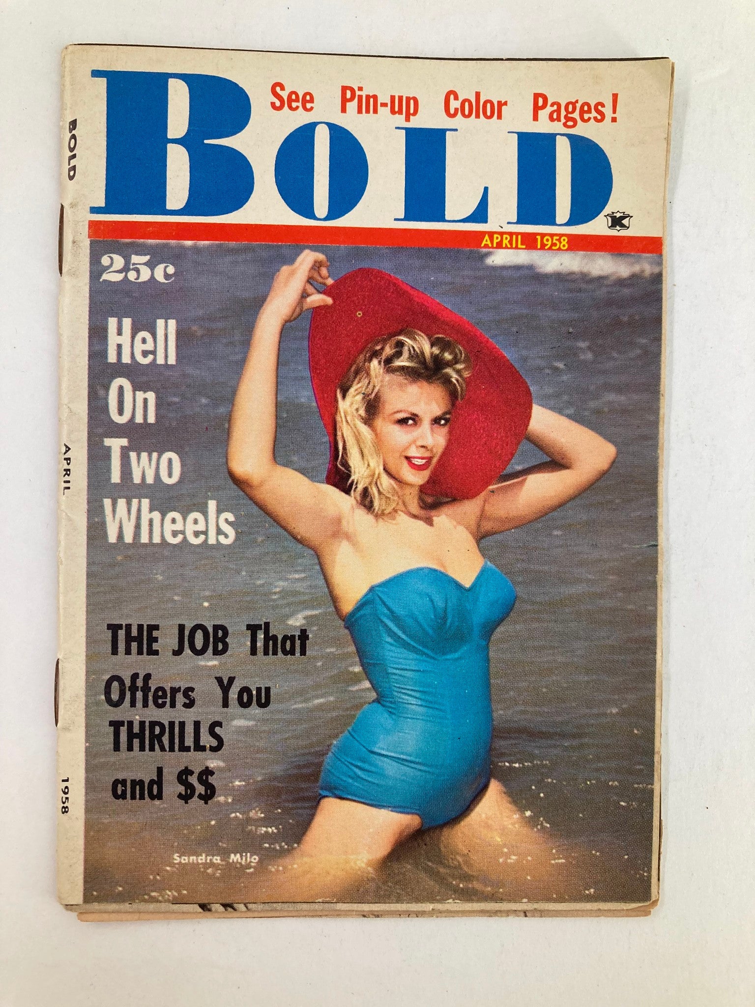 Cover of VTG Bold Magazine April 1958 featuring a young woman in a blue swimsuit at the beach, showcasing the article 'The Job That Offers You Thrills and $$'. The magazine highlights pin-up color pages.