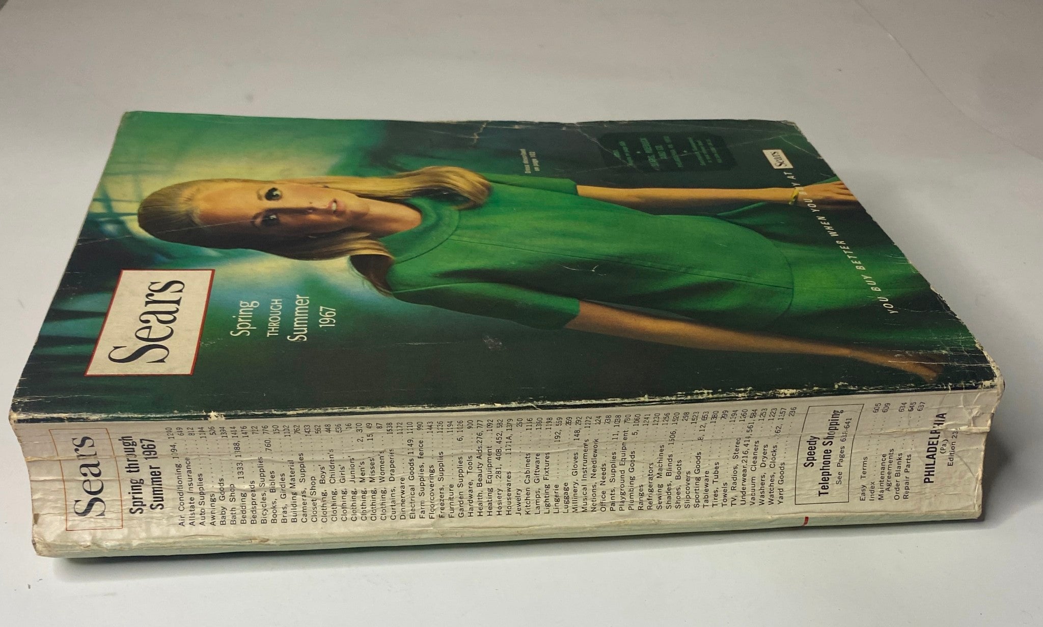 Cover of the 1967 Sears Spring Through Summer Catalog featuring a model in a green dress, showcasing vintage fashion from the 1960s.