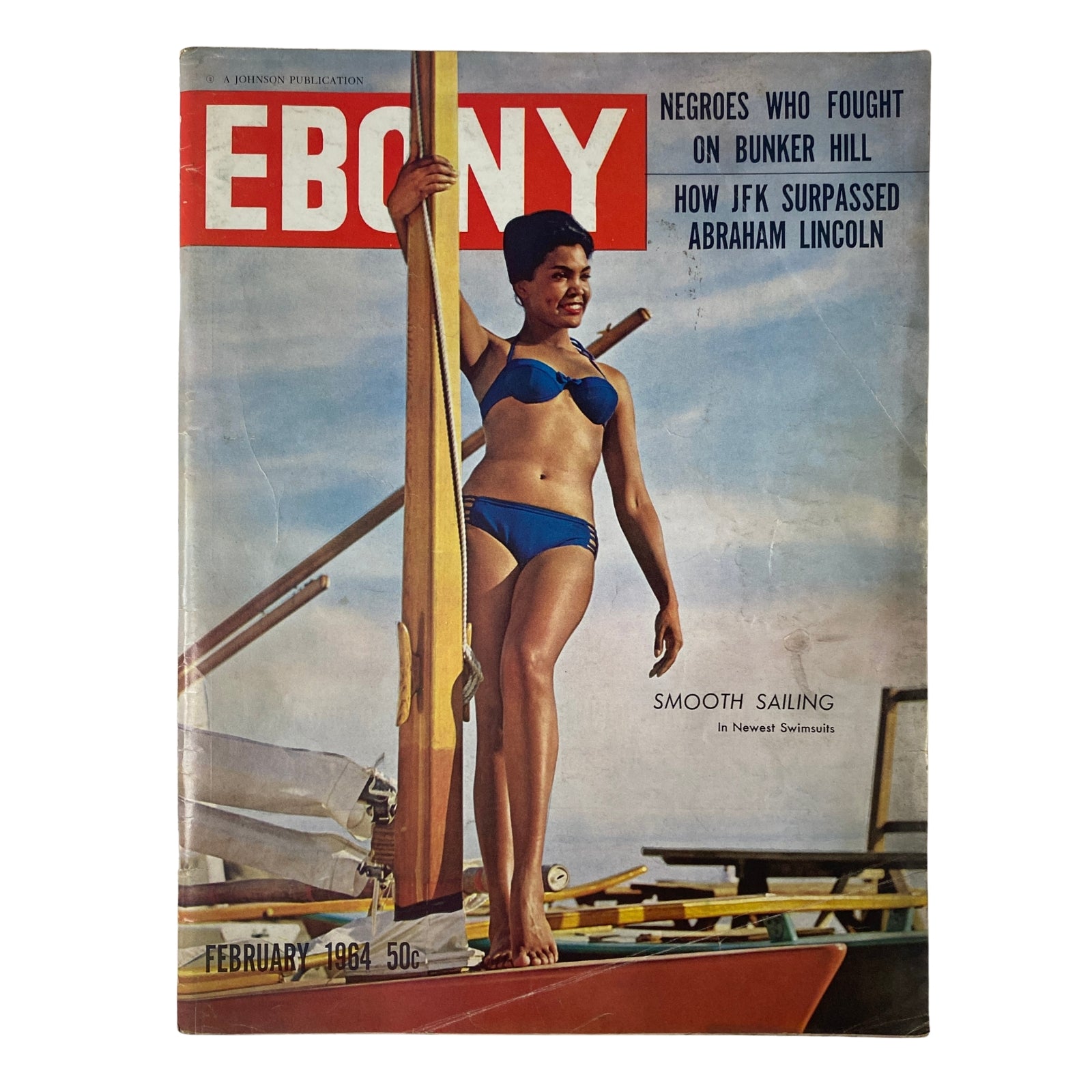 Cover of Ebony Magazine February 1964 featuring model Janie Burdette in a blue bikini, showcasing themes of fashion, culture, and civil rights with articles on historical topics and prominent figures.
