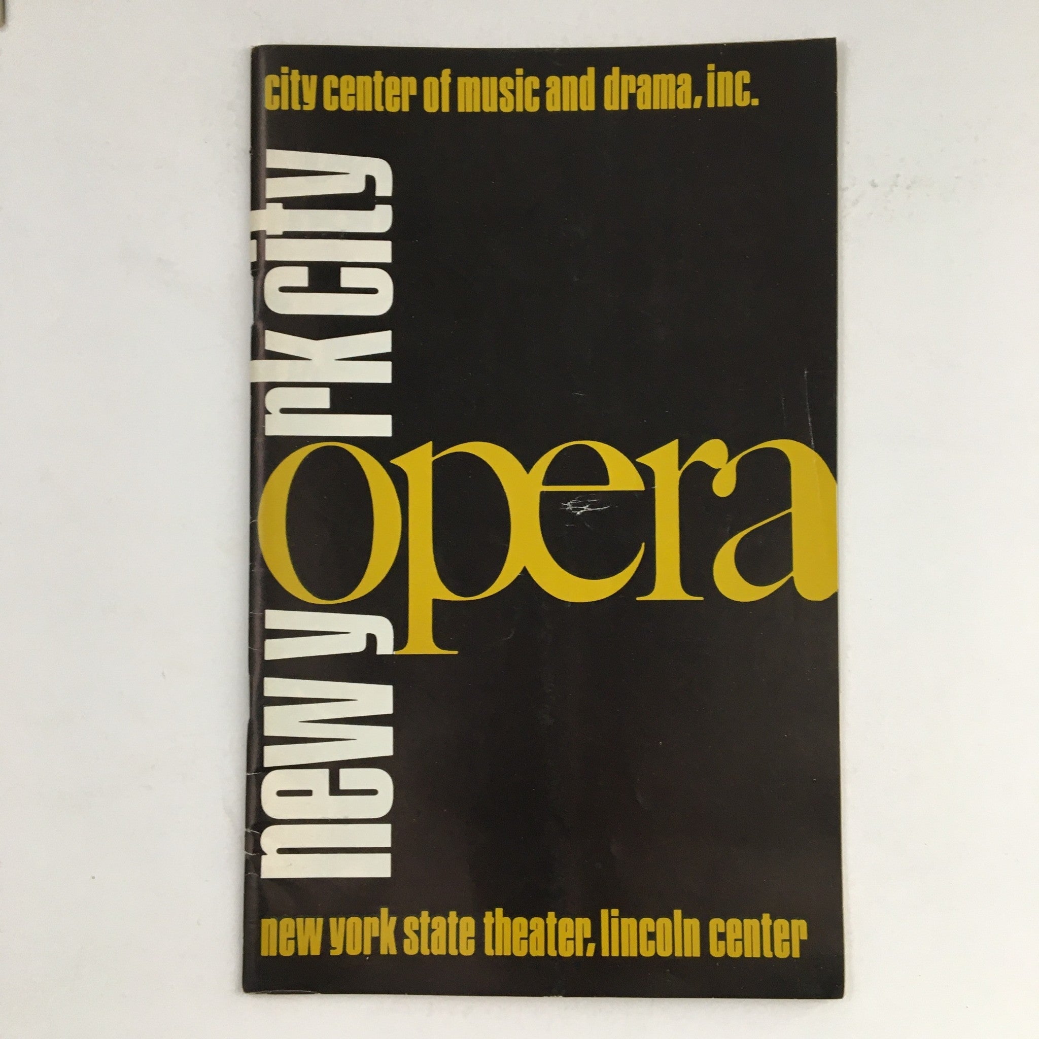 Cover of the 1972 City Center of Music and Drama Present New York City Opera magazine by Julius Rodel, featuring bold typography in black and yellow, showcasing the artistic spirit of the era.