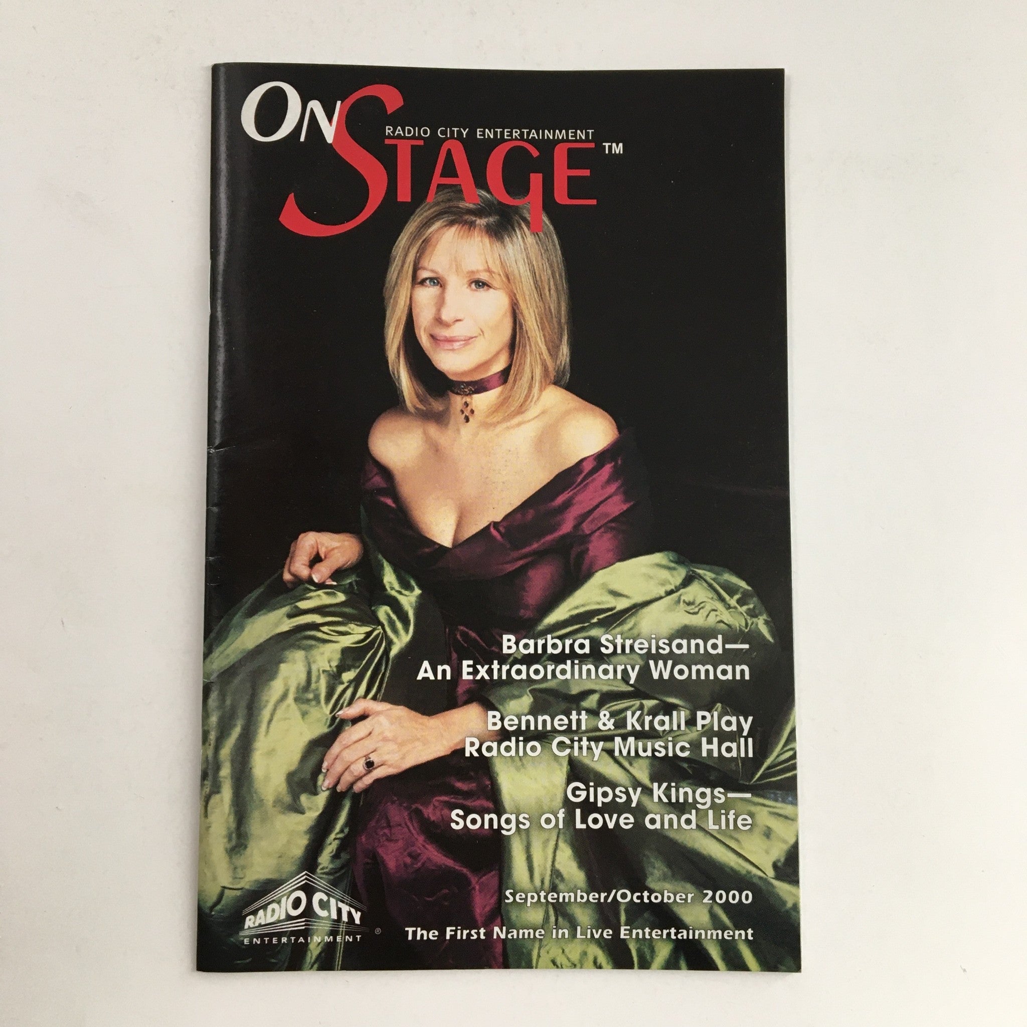 Cover of On Stage magazine featuring Barbra Streisand titled '2000 On Stage Radio City Entertainment Barbra Streisand An Extraordinary Woman'. The cover highlights Barbra Streisand in a glamorous pose wearing a green gown.