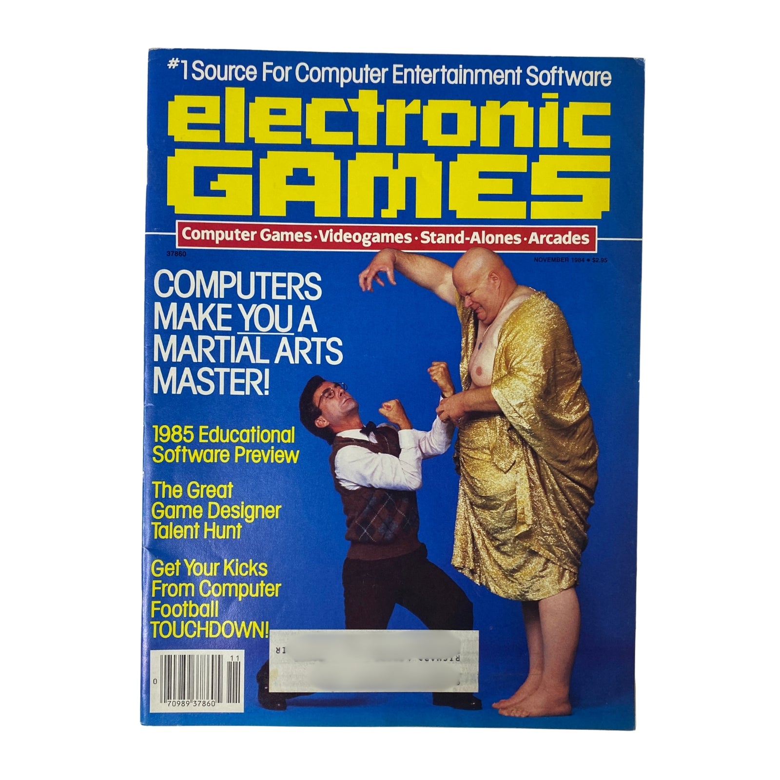 Cover of Electronic Games Magazine from November 1984 featuring the title 'Electronic Games Magazine November 1984 The 1985 Educational Software Preview'. The magazine showcases highlights from the gaming industry, illustrated with a humorous martial arts theme and a large figure alongside a smaller character. The cover emphasizes topics such as educational software and video games.