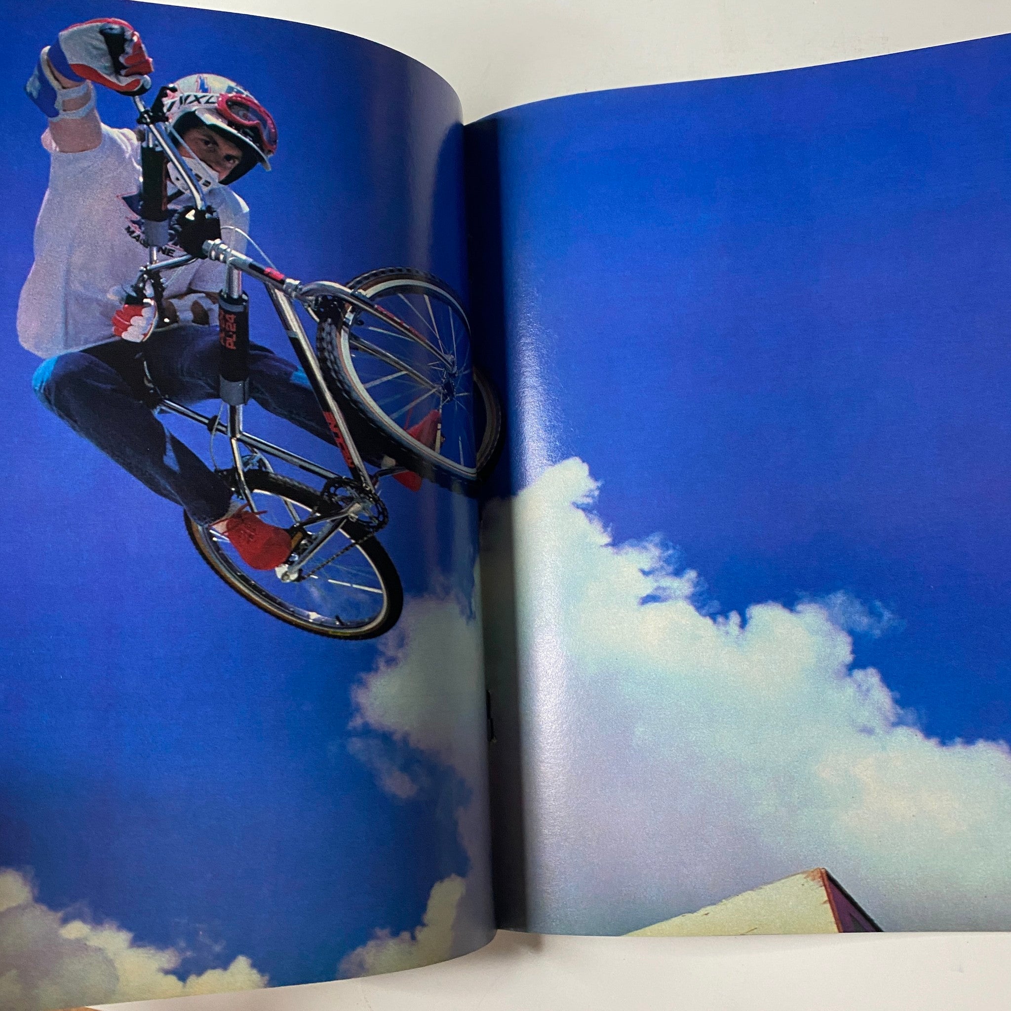 Inside spread from BMX Action Magazine May 1983 Vol 8 No. 5 depicting a BMX rider performing a trick against a backdrop of blue sky and clouds.