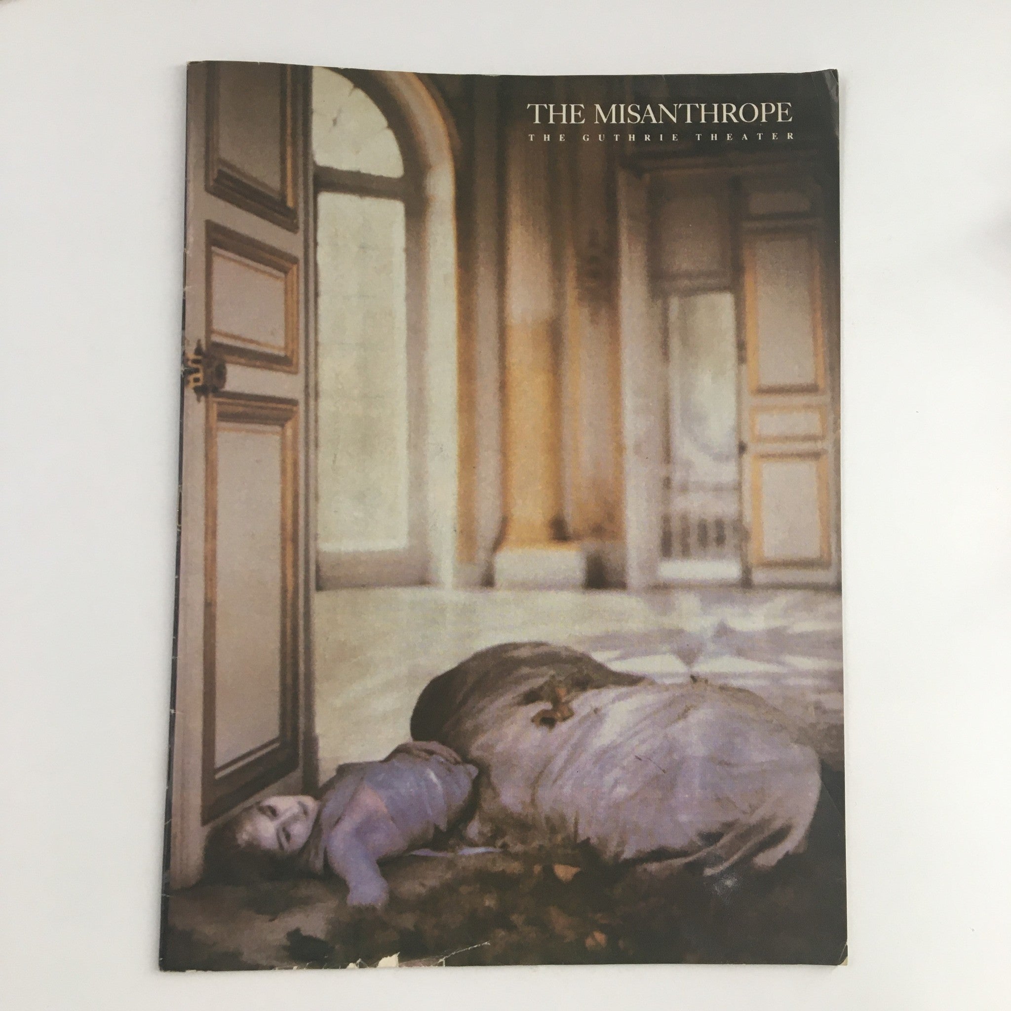 Cover of the 1988 production program for 'The Misanthrope' presented by The Guthrie Theater, featuring an artistic image of a figure lying down in a stylized setting.