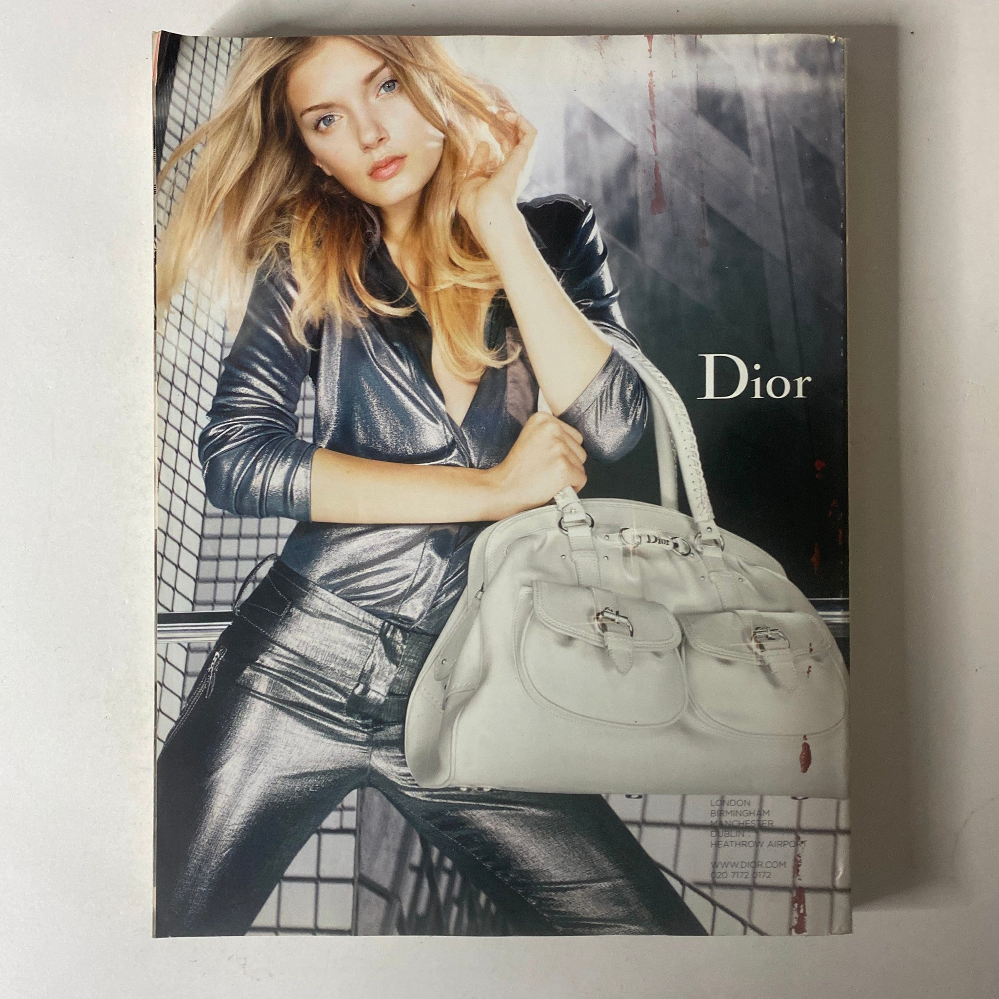Image from Vogue British Magazine December 2006 featuring a Dior fashion advertisement with a model in silver attire and a stylish handbag.