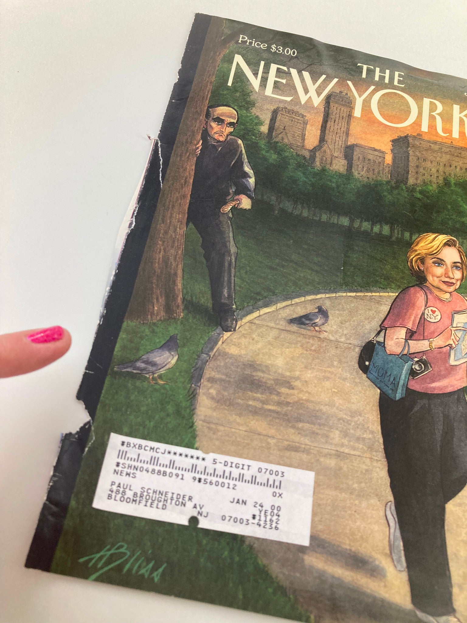 Detailed view of The New Yorker July 19, 1999 cover 'The Tough Guy & The Tourist', highlighting the wear and an address label, with a woman walking in a park.