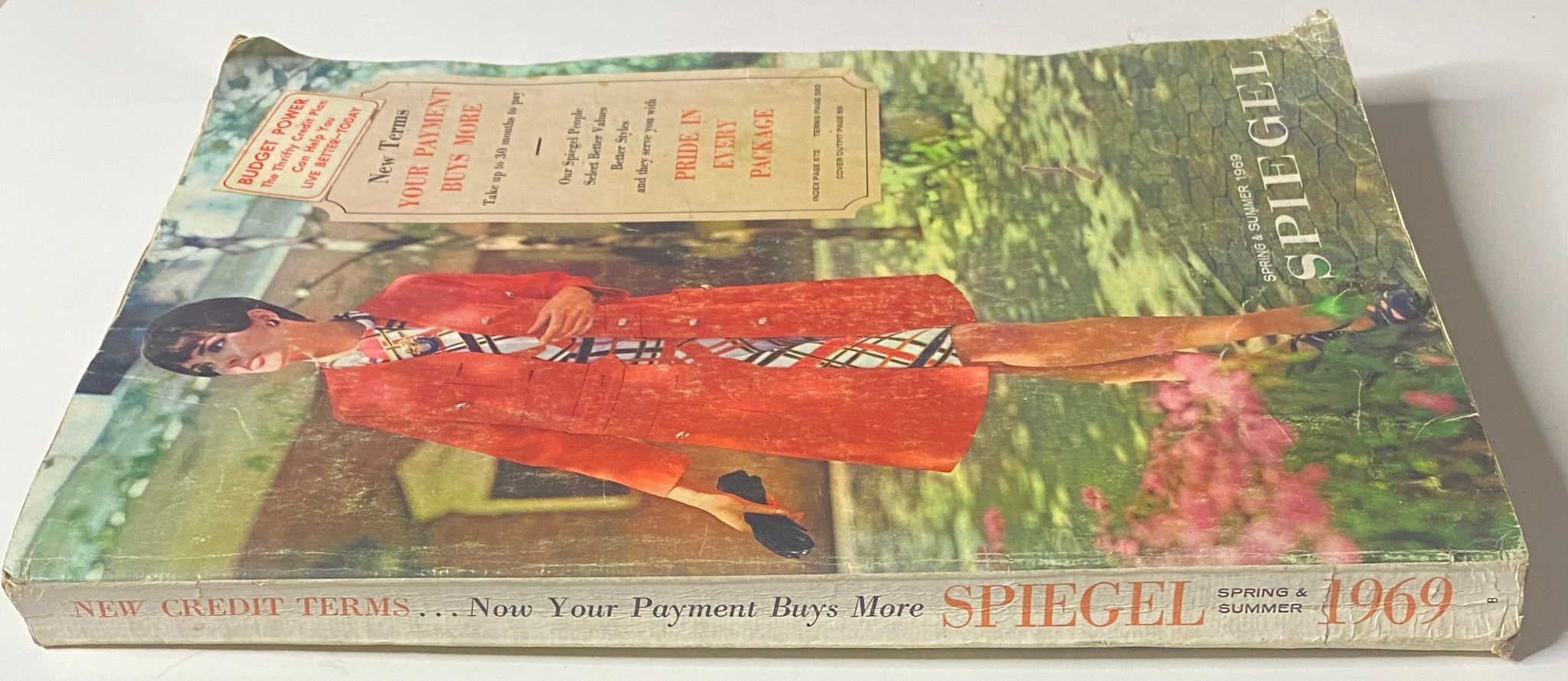 Cover of the 1969 Spiegel Spring and Summer Catalog displaying a model in a vibrant red coat with a stylish dress, showcasing the retro fashion of the late 1960s.