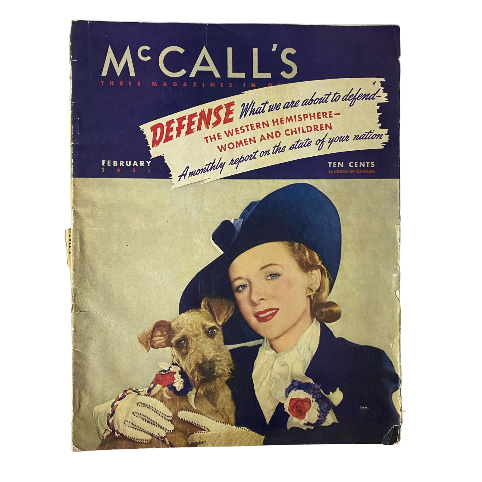 Cover of McCall's Three Magazine in One, February 1941 edition featuring a woman in a blue hat with a dog, highlighting the theme of 'Defense' and promoting the magazine's focus on wartime issues.