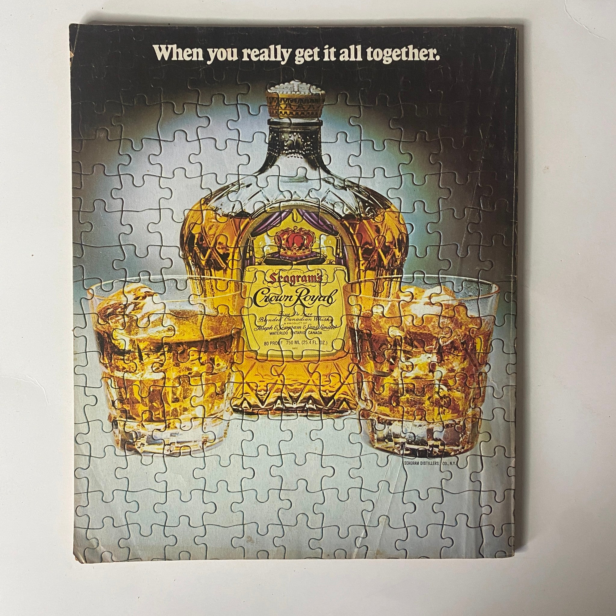 Puzzle cover of a vintage advertisement featuring an elegant whiskey bottle and glasses, complementing the insightful content of Fortune Magazine July 2, 1979.