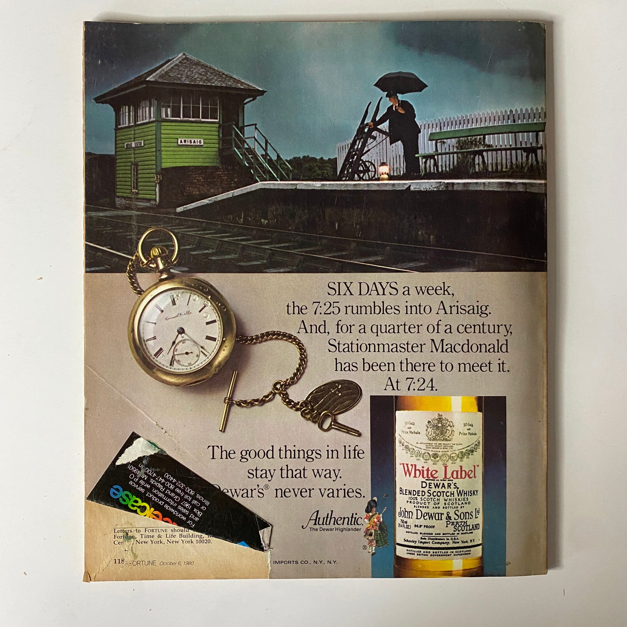 Back cover of a magazine featuring a vintage clock, advertising Dewar's White Label whisky, alongside a description of the train service in Arisaig from the 1980 issue of Fortune Magazine.