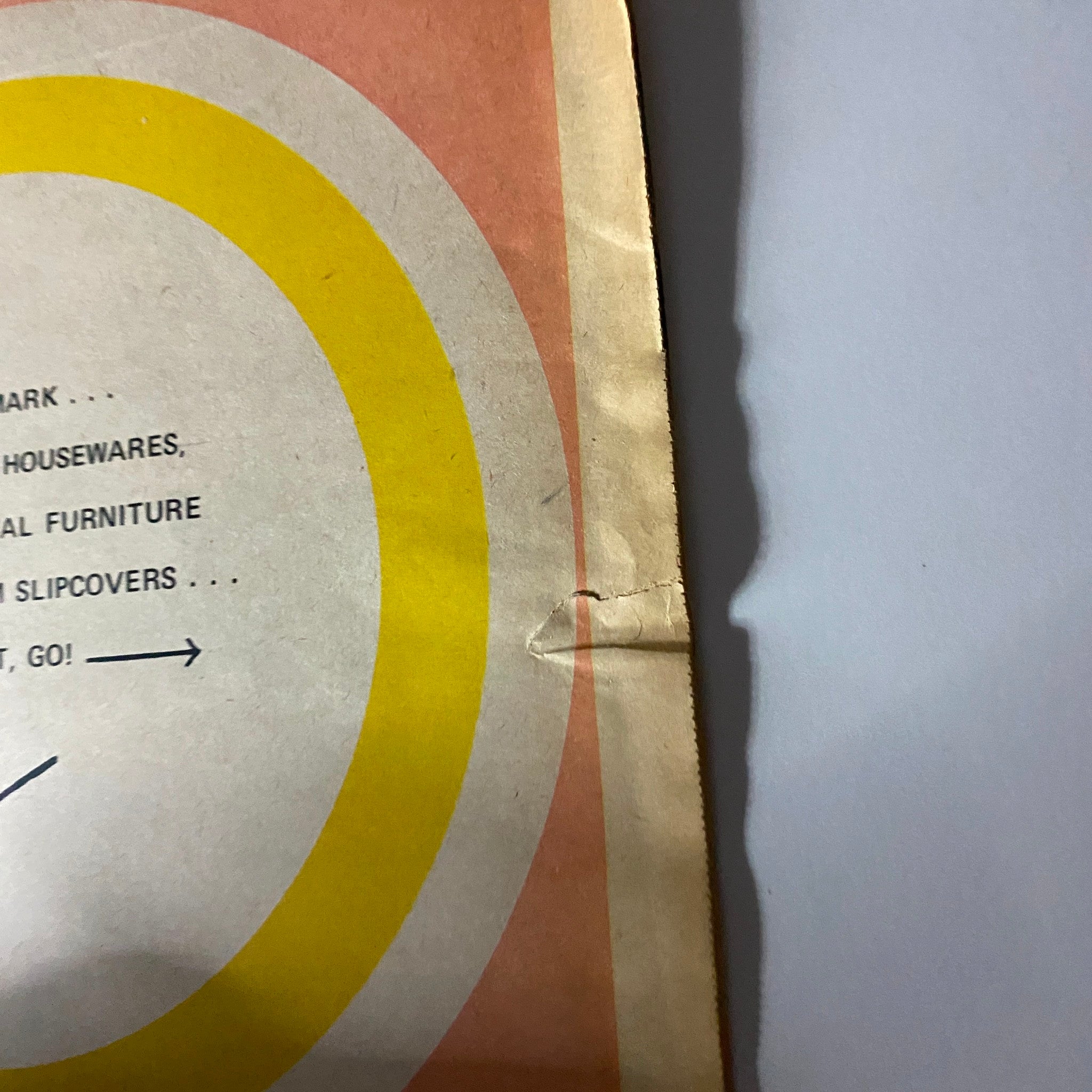 Close-up detail of the cover of The New York Times Magazine Bloomingdale's No Label, showcasing the unique circular design and a crease at the edge.