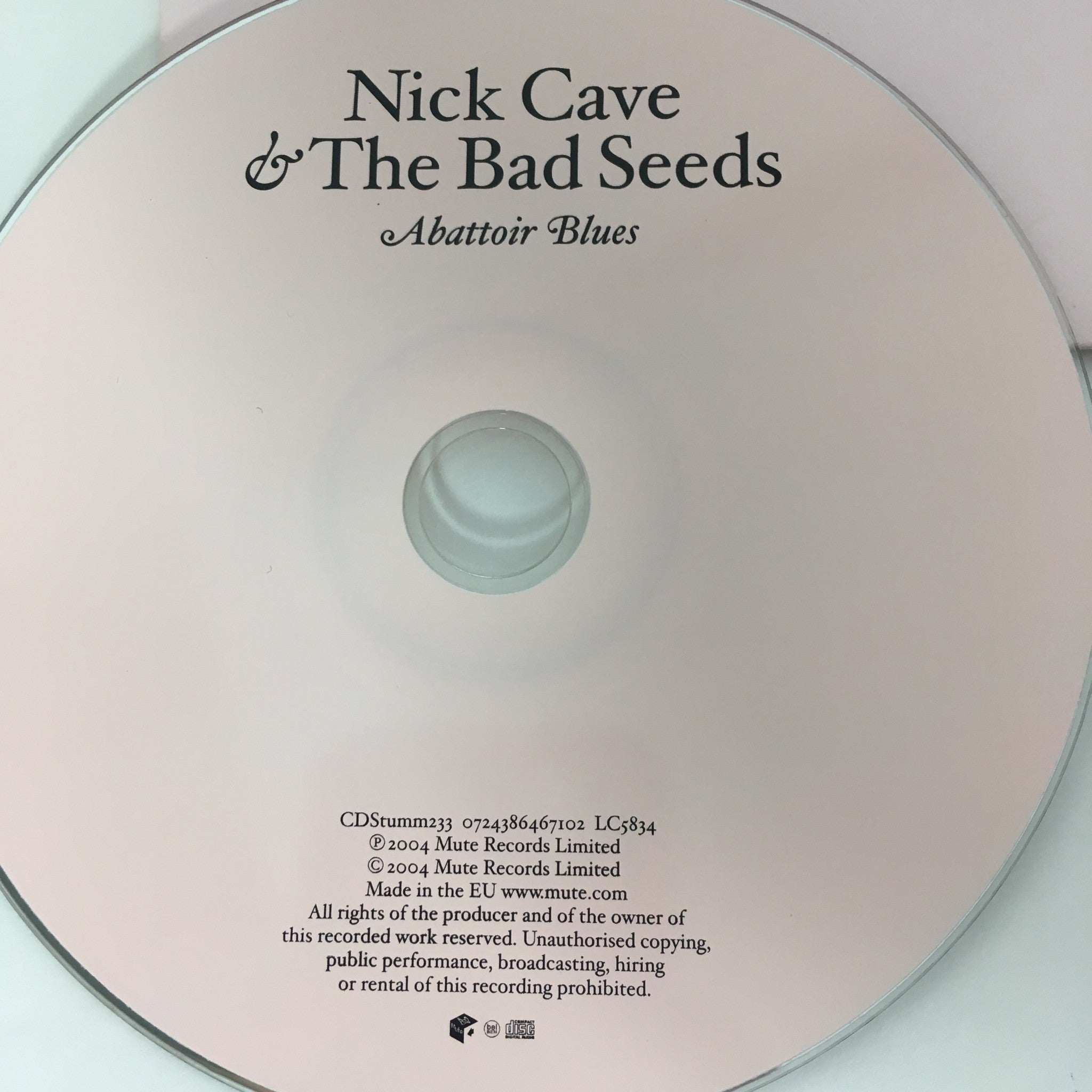 Close-up view of the disc for 'Abattoir Blues / The Lyre of Orpheus' by Nick Cave & The Bad Seeds, featuring a pink surface with text details.