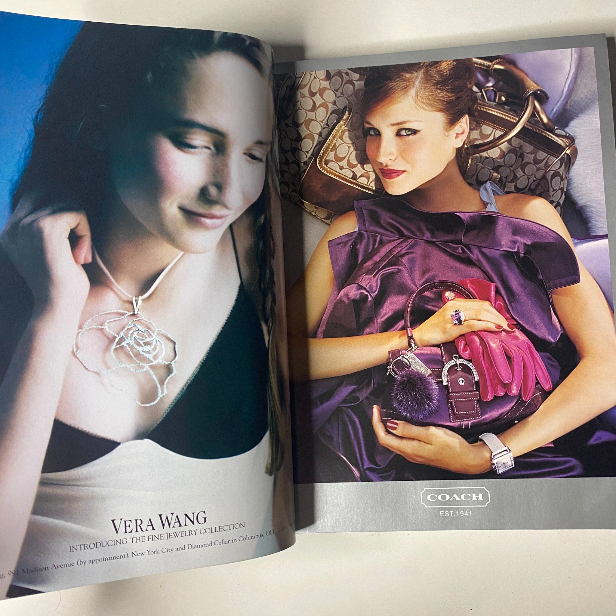 Interior pages of Vogue Magazine December 2004 displaying advertisements for Vera Wang jewelry and Coach bags, reflecting luxury fashion trends.