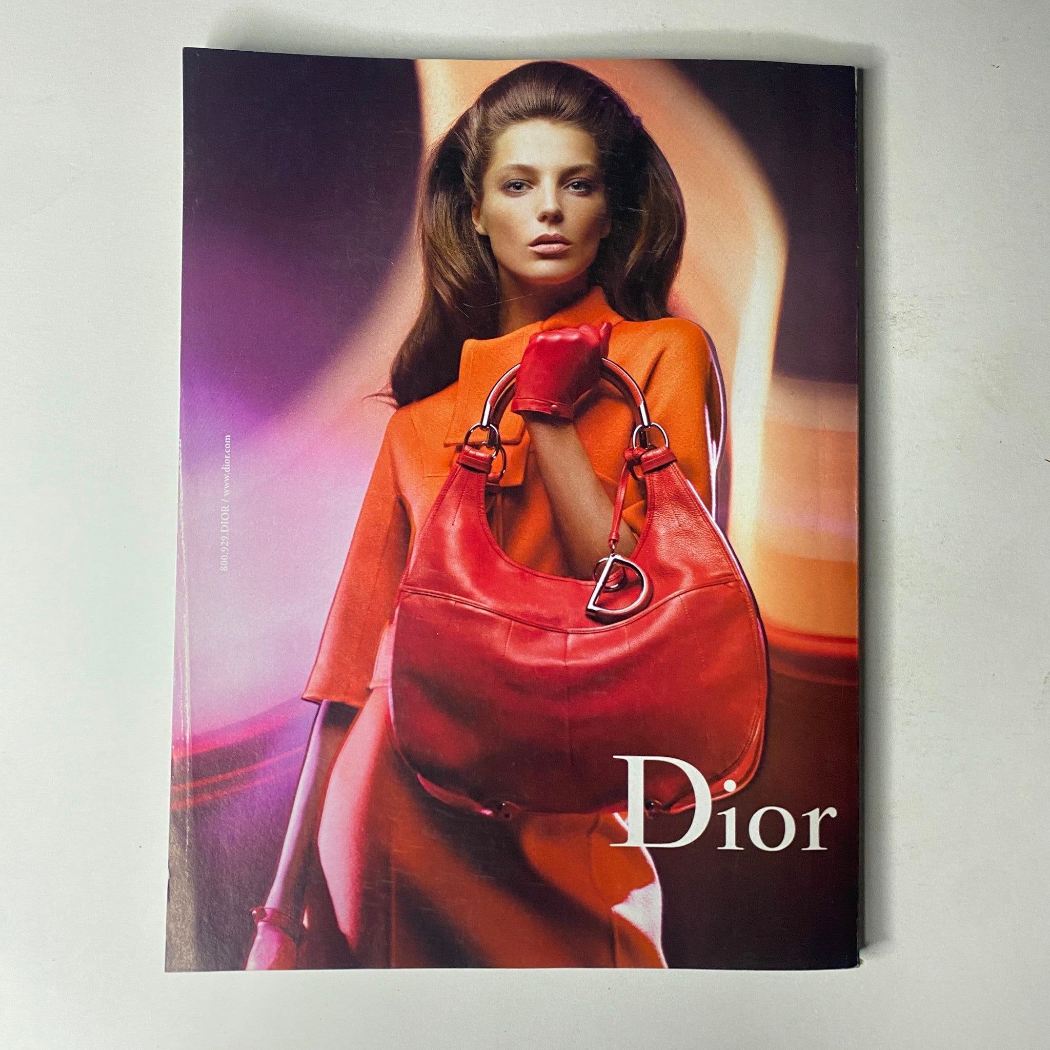 Dior advertisement featured in Vogue Magazine August 2008 showcasing a model in a striking orange outfit paired with a red handbag, capturing high-fashion essence.