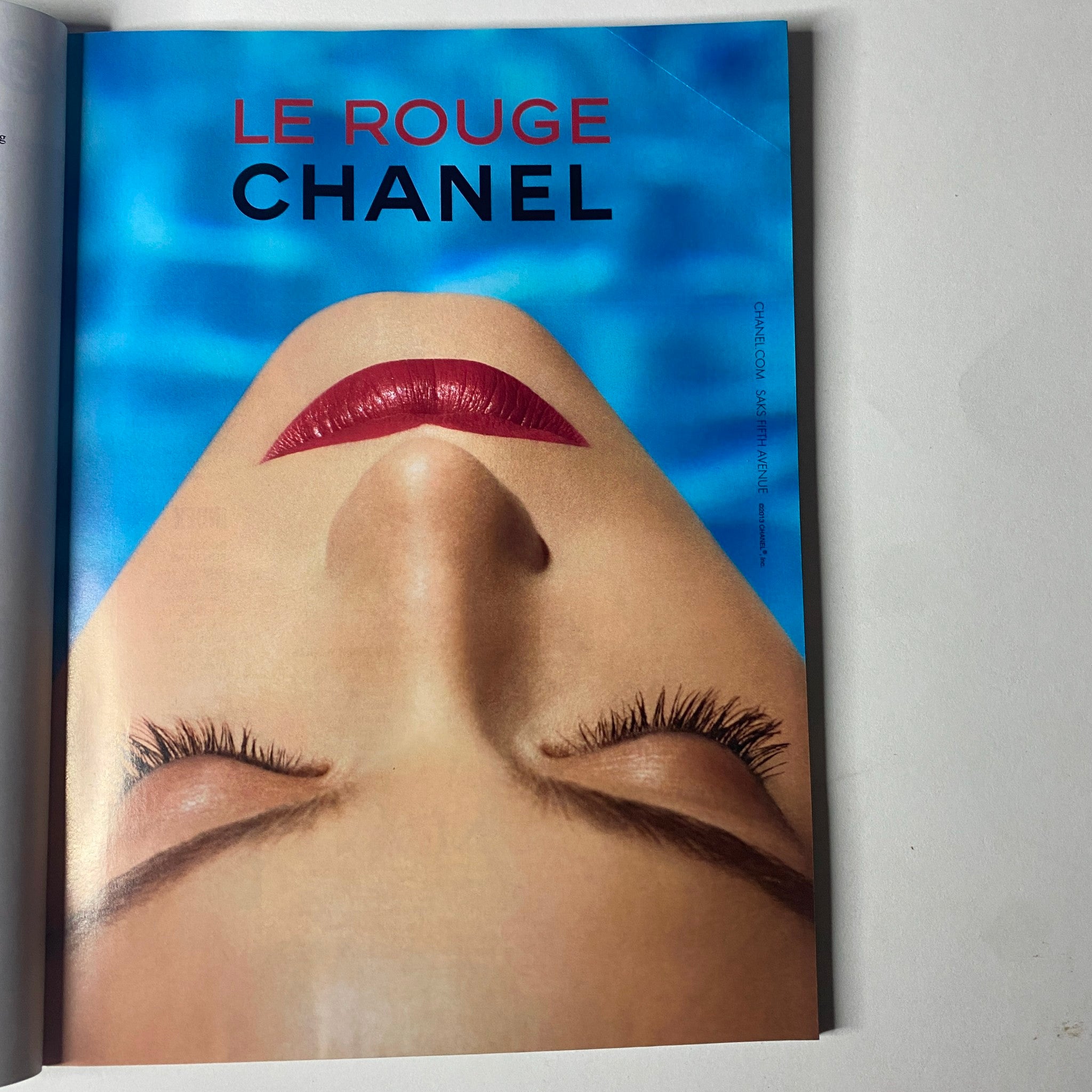 A Chanel advertisement from Vogue Magazine June 2013 featuring a close-up of a model with bold red lips and prolonged eyelashes, promoting their 'Le Rouge' line.