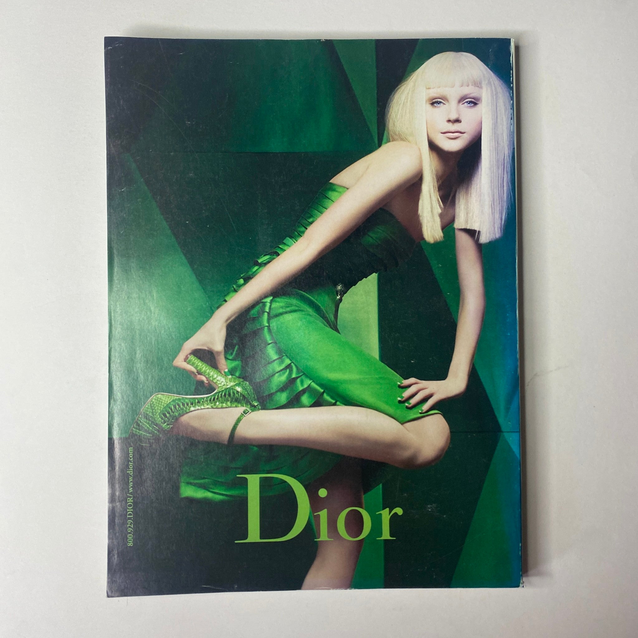 Dior advertisement displaying a model in a vibrant green dress, striking a pose, from Vogue Magazine August 2007 with Winona Ryder on the cover.