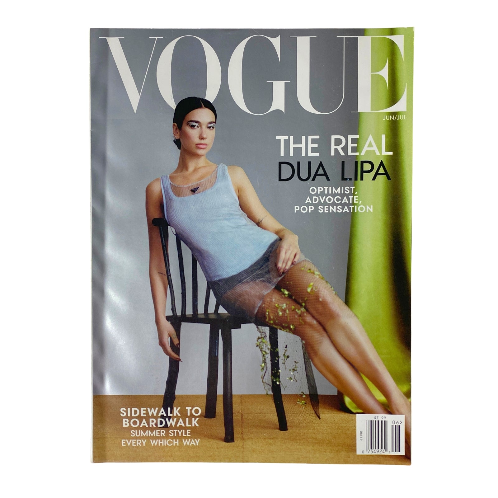 Vogue Magazine June/July 2022 featuring Dua Lipa on the cover in a sleeveless outfit, styled in a contemporary fashion while seated on a chair.