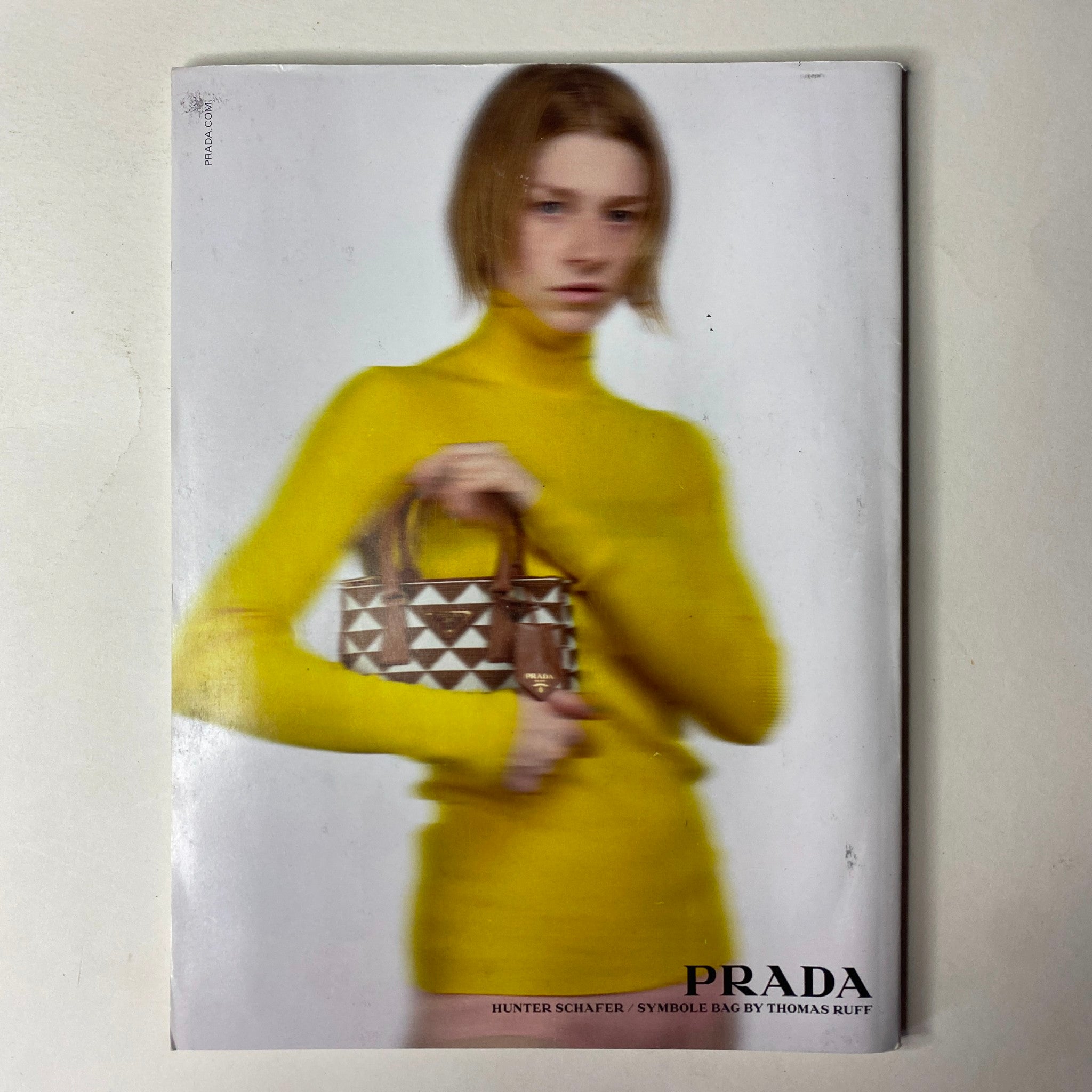 Vogue Magazine June/July 2022 featuring Dua Lipa on the cover, with a close-up of a model styled in metallic Prada, conveying the essence of modern fashion and cultural exploration.