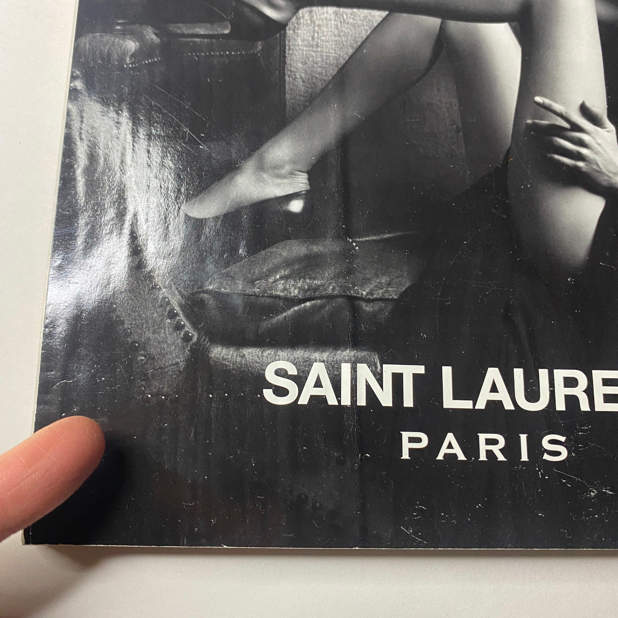 Close-up detail of the Saint Laurent Paris magazine cover, featuring a model in a dramatic position, showcasing the allure of minimalist fashion photography.