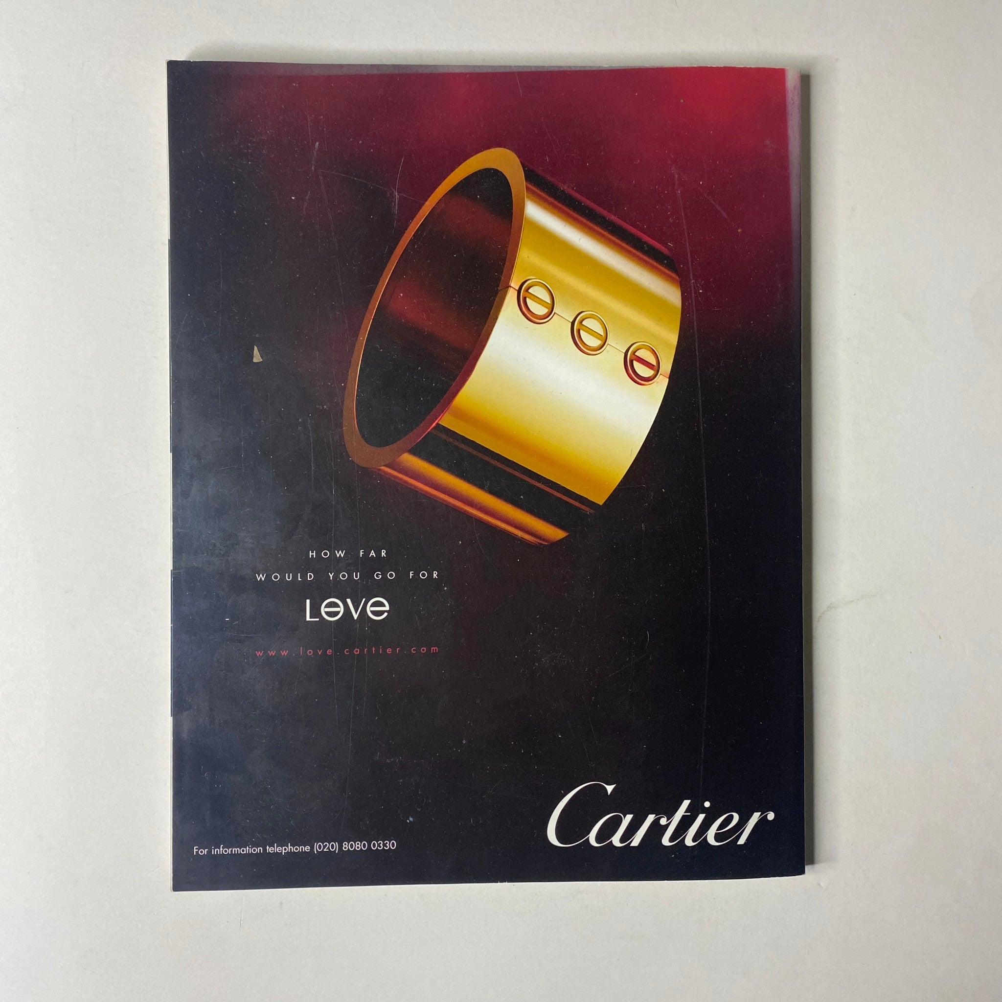 Back cover advertisement of Cartier featured in Vogue British Magazine July 2007, displaying a luxurious gold bracelet with the tagline 'How far would you go for love?'.
