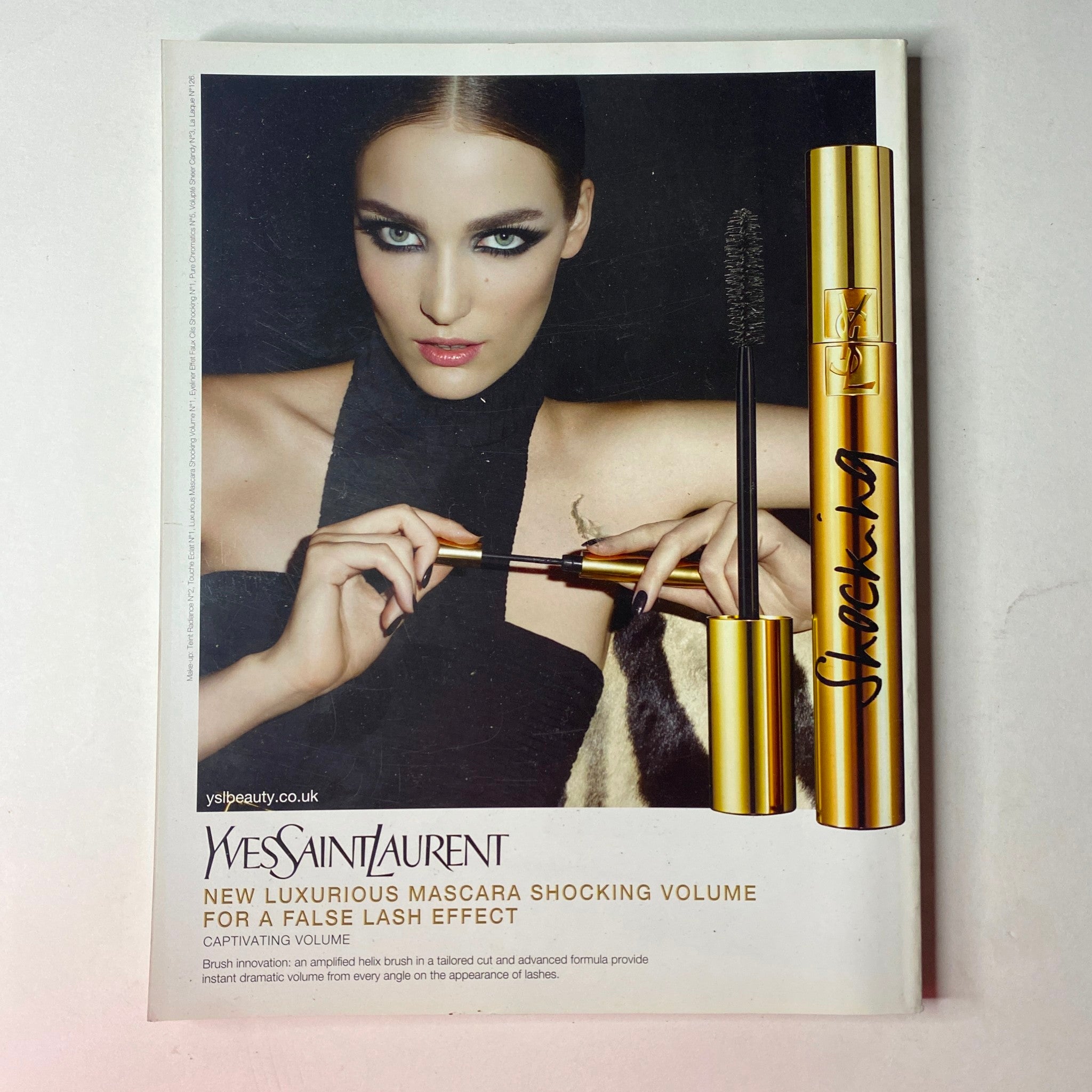 Yves Saint Laurent mascara advertisement highlighting a model applying mascara for dramatic volume, from Vogue British Magazine May 2012 Charlize Theron Cover No Label VG.