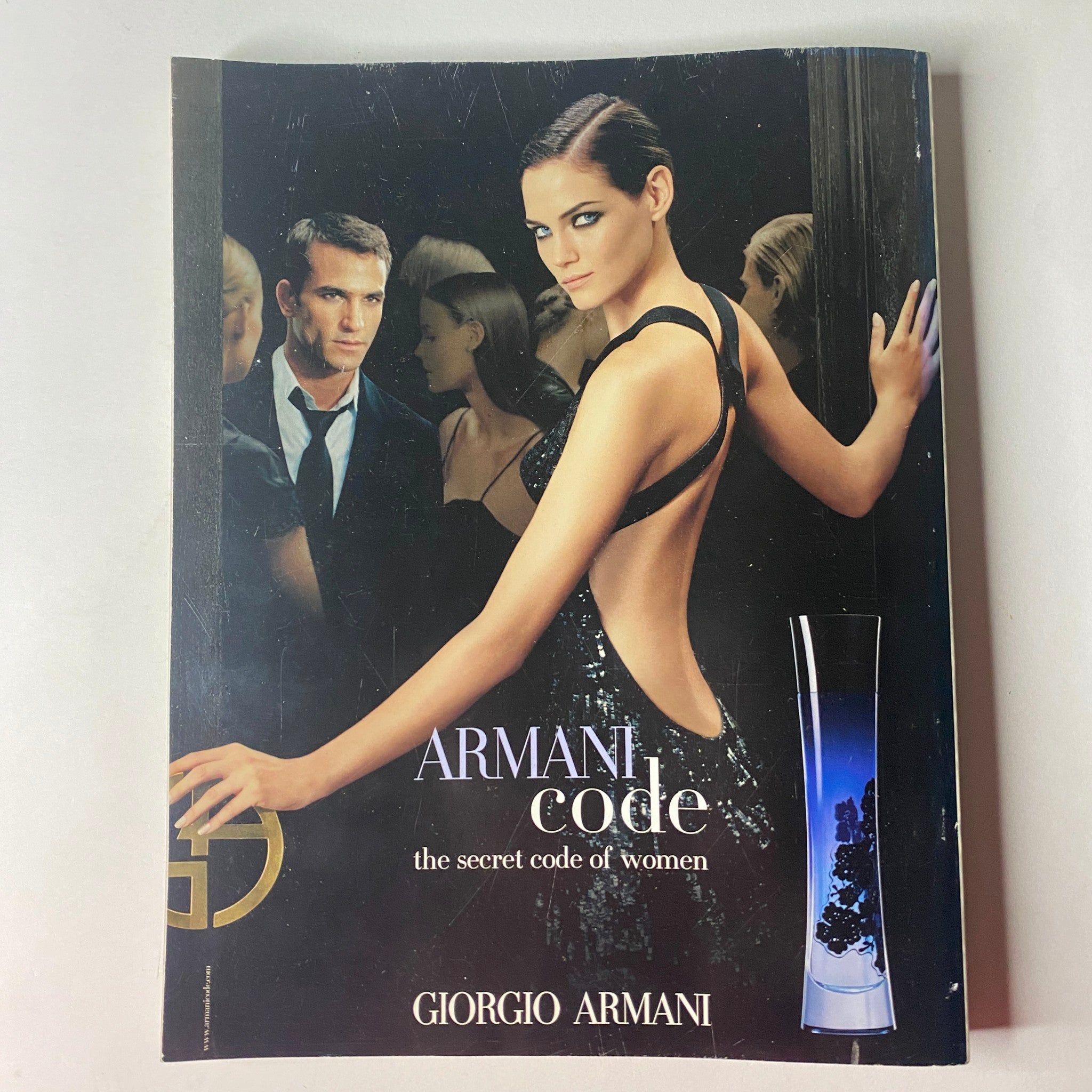 Giorgio Armani advertisement for Armani Code, featuring a striking model in a backless gown, embodying elegance and allure, from Vogue British Magazine November 2006.