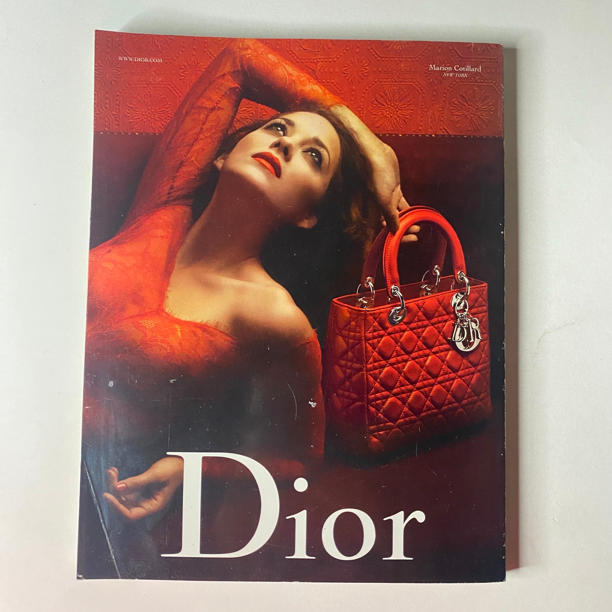 Dior advertisement featured in Vogue British Magazine December 2009, showcasing a stunning model in vibrant red attire, emphasizing luxury fashion.