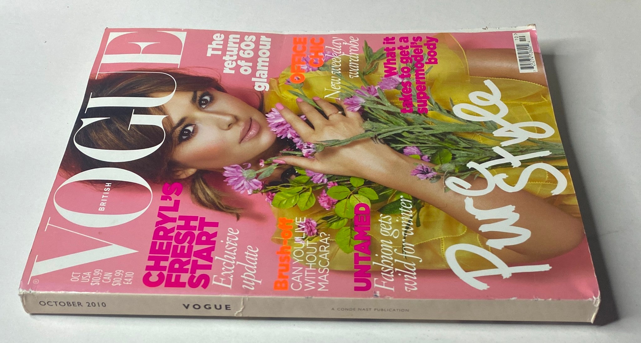 Close-up view of the October 2010 issue of Vogue British Magazine with Cheryl Cole on the cover, featuring topics like 'Cheryl's Fresh Start', office chic, and fashion trends for the winter season.
