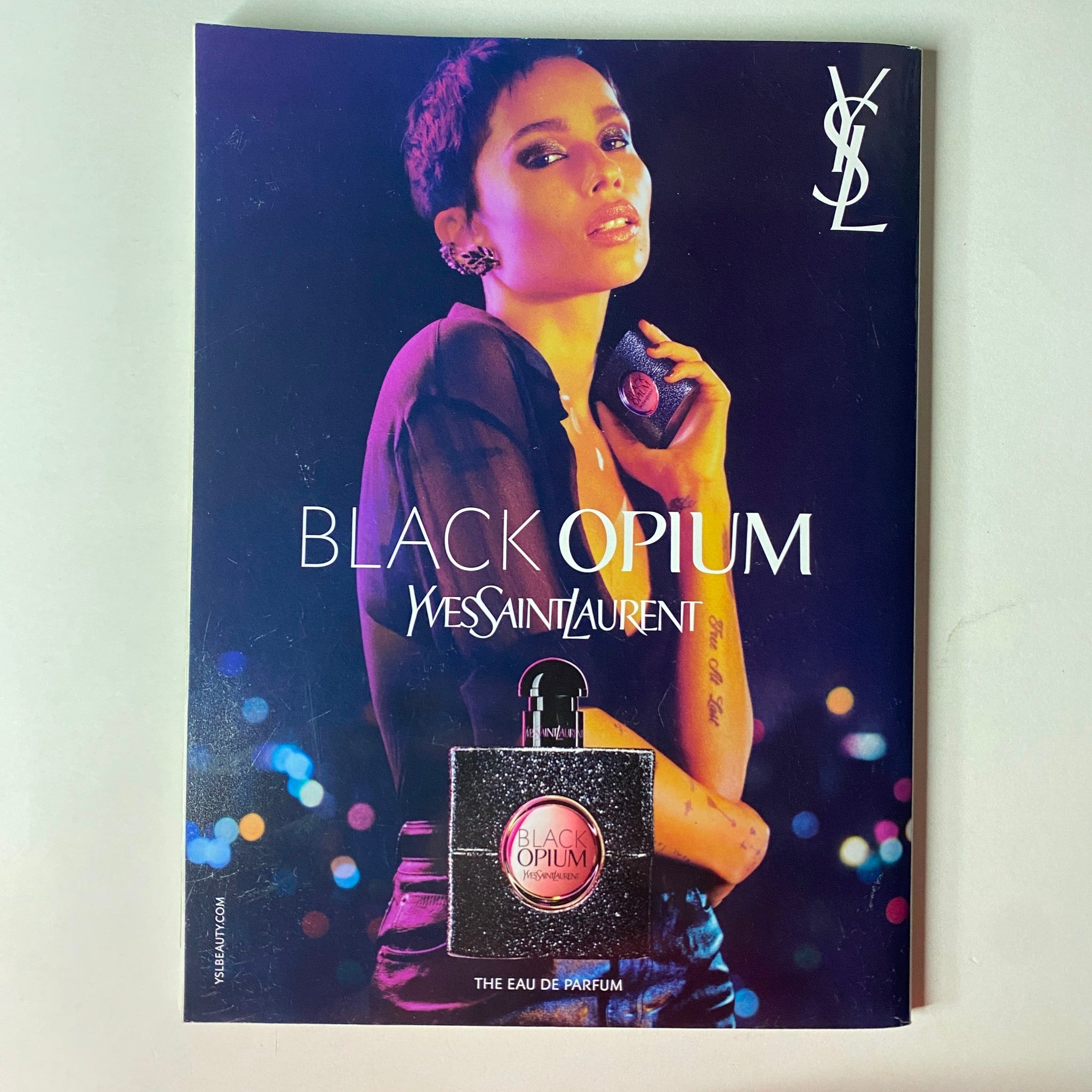 Promotional page for Yves Saint Laurent Black Opium fragrance in Vogue British Magazine May 2022, featuring a model with an illuminated background.
