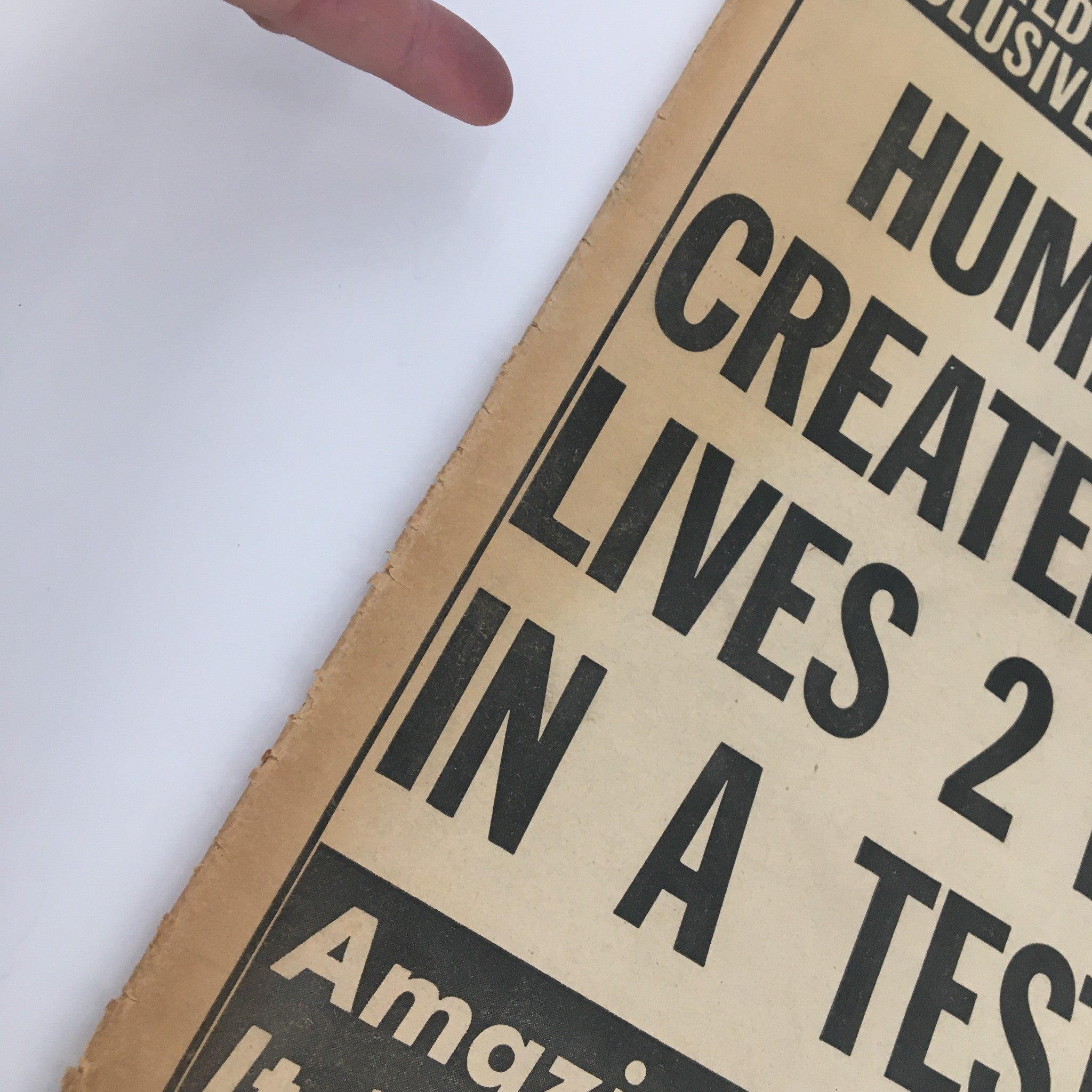 Close-up view of the National Enquirer Newspaper from June 11, 1961, highlighting the headline 'Human Baby Created In Lab Lives 2 Months In A Test Tube'. The image shows minor wear on the edges, indicating its vintage nature.