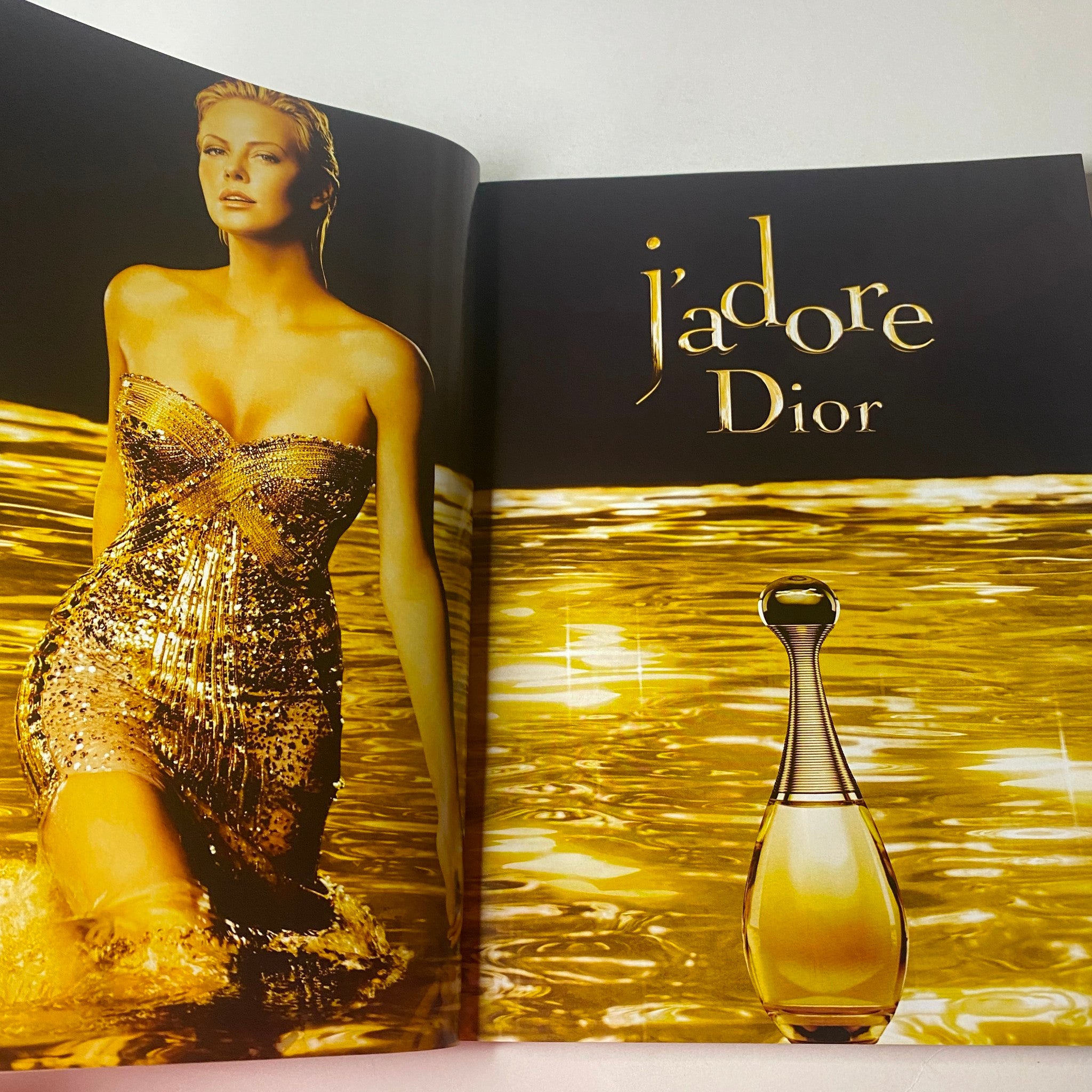 Ad page featuring a glamorous model in a golden dress for Dior's J'adore fragrance from Vogue British Magazine May 2010.
